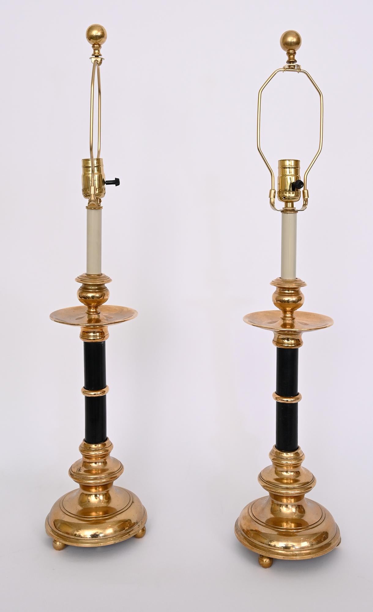 A pair of Swedish bronze and ebonized wood candlesticks by the Swedish foundry Skultuna c. 1900. 
Bases have individual signature codes stamped on the underside.
Mounted as lamps with adjustable harp fitting and single medium socket.
Shades not