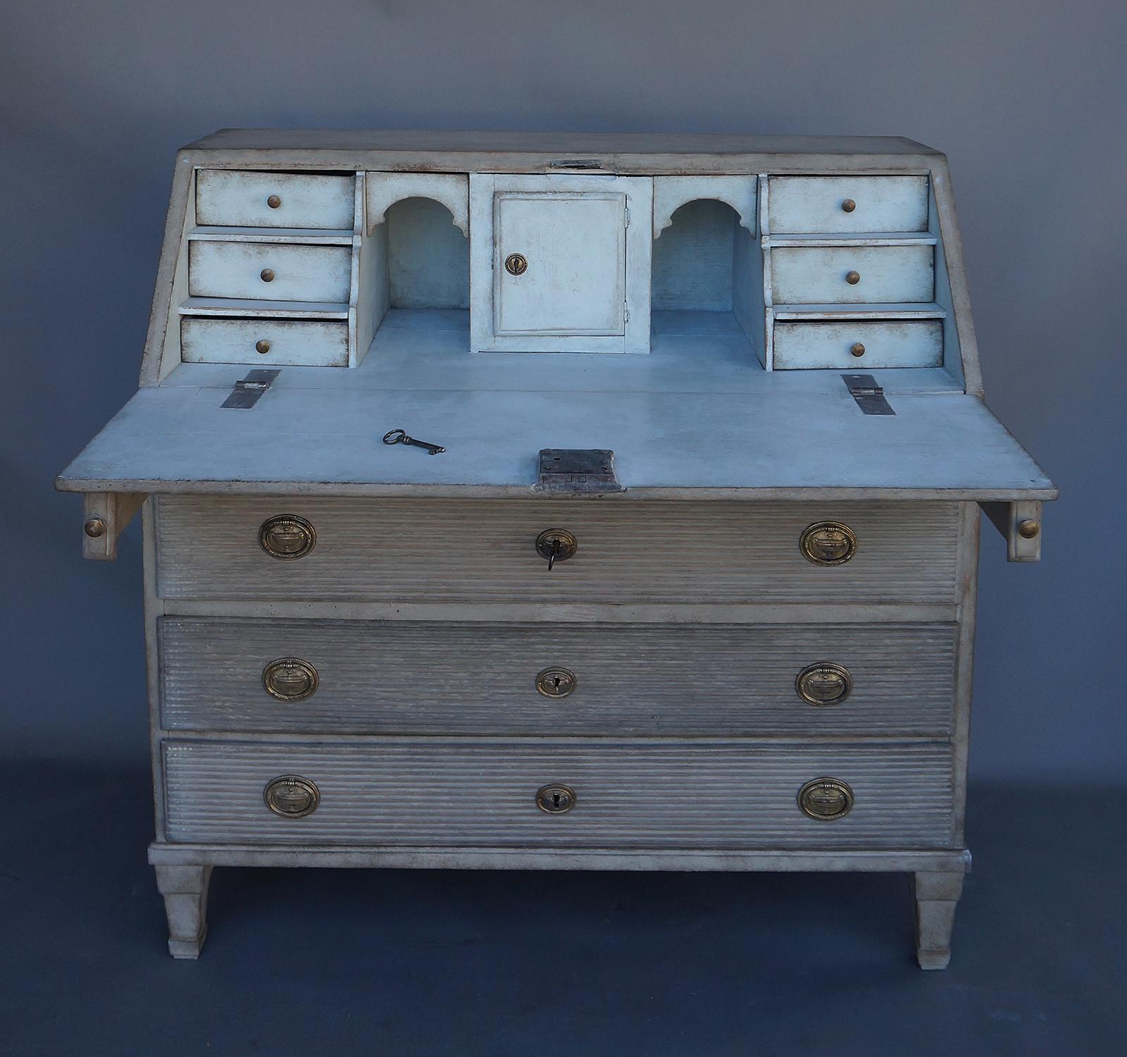 Period Gustavian writing desk, circa 1820, with slant front and fitted interior. The three full-width drawers and a narrow pencil drawer as well as the slant front have horizontal reeding and later brass hardware. The interior has six drawers with