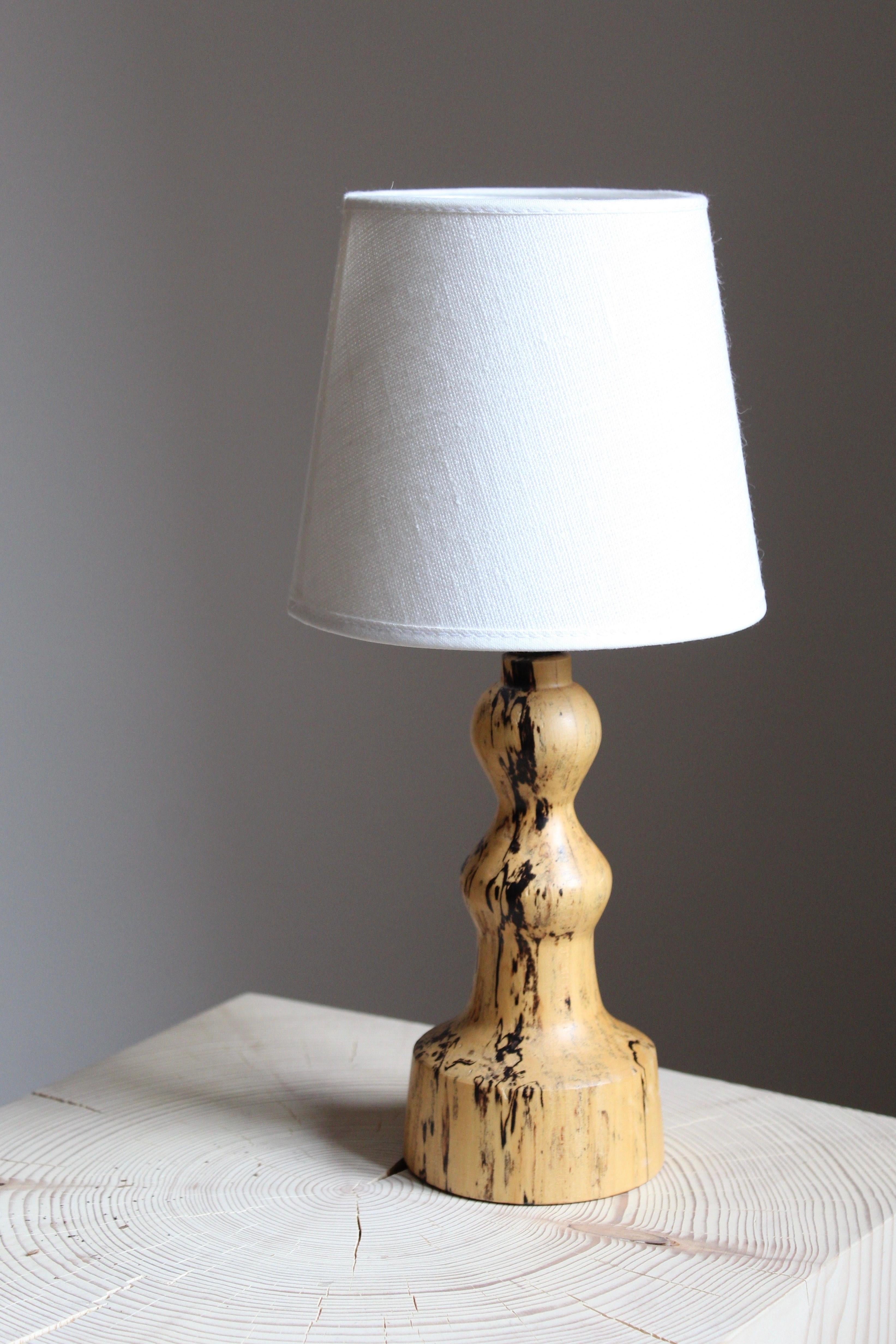 A Swedish craft table lamp. In turned solid Masur birch, Sweden, 1960s. Sold without lampshade.

  