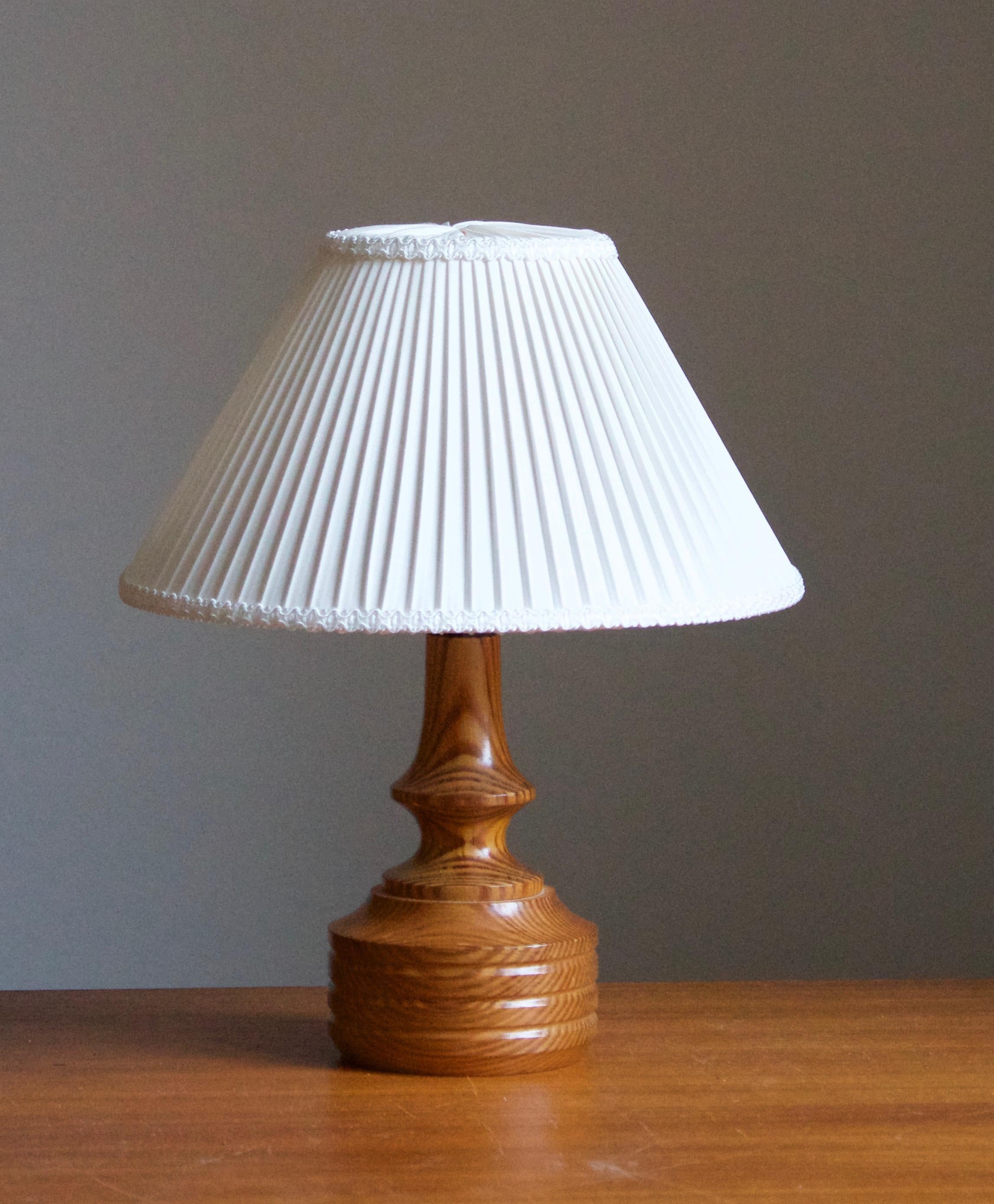 A small pine table lamp, designed and produced in Sweden, c. 1970s. 

Stated dimensions exclude lampshade. Height includes socket. Sold without lampshade.