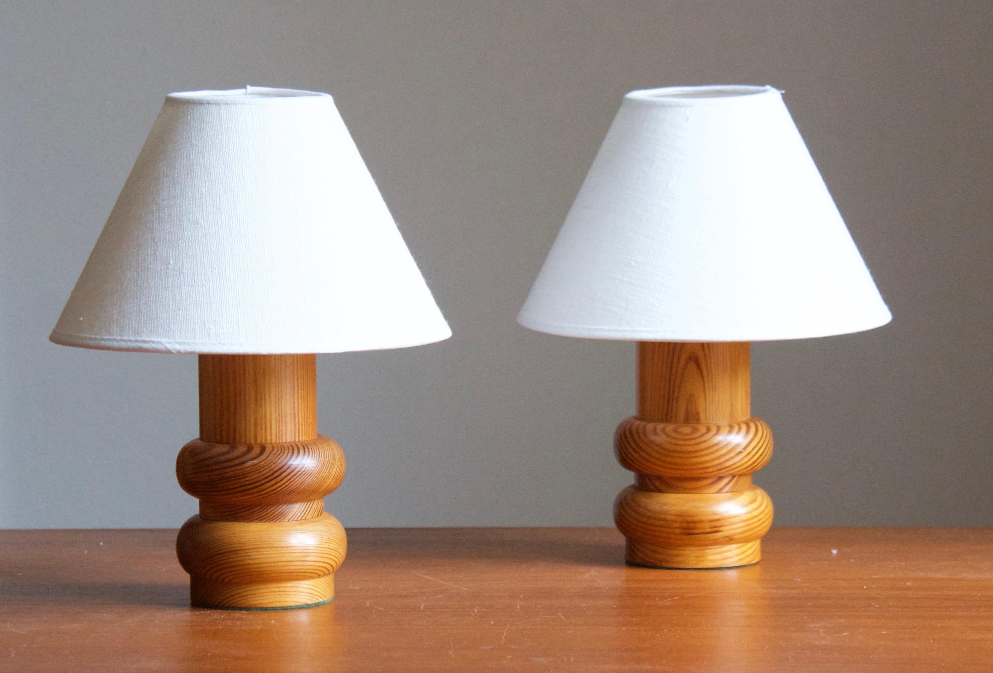 A pair of small pine table lamps, designed and produced in Sweden, c. 1970s. 

Stated dimensions exclude lampshade. Height includes socket. Sold without lampshades.