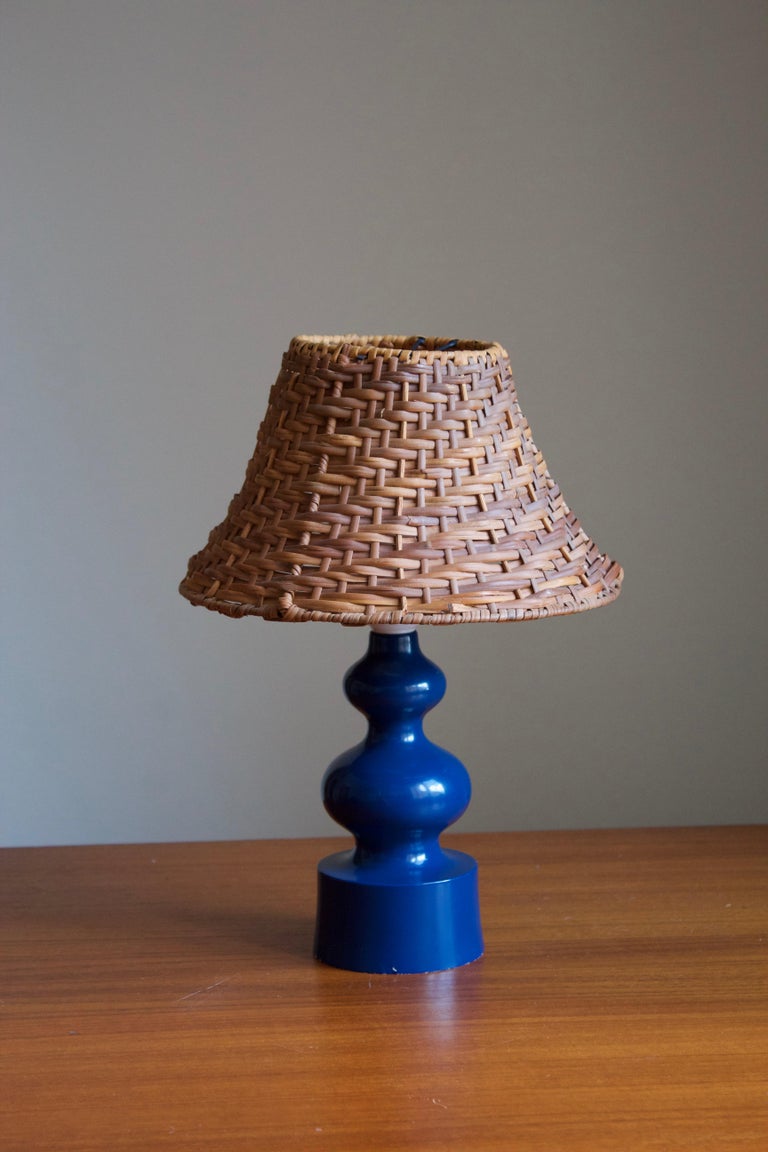 A table lamp. Base in blue-painted solid wood.

Stated dimensions exclude lampshade, height includes socket. Upon request illustrated lampshade can be included in purchase.

Glaze features a blue color.