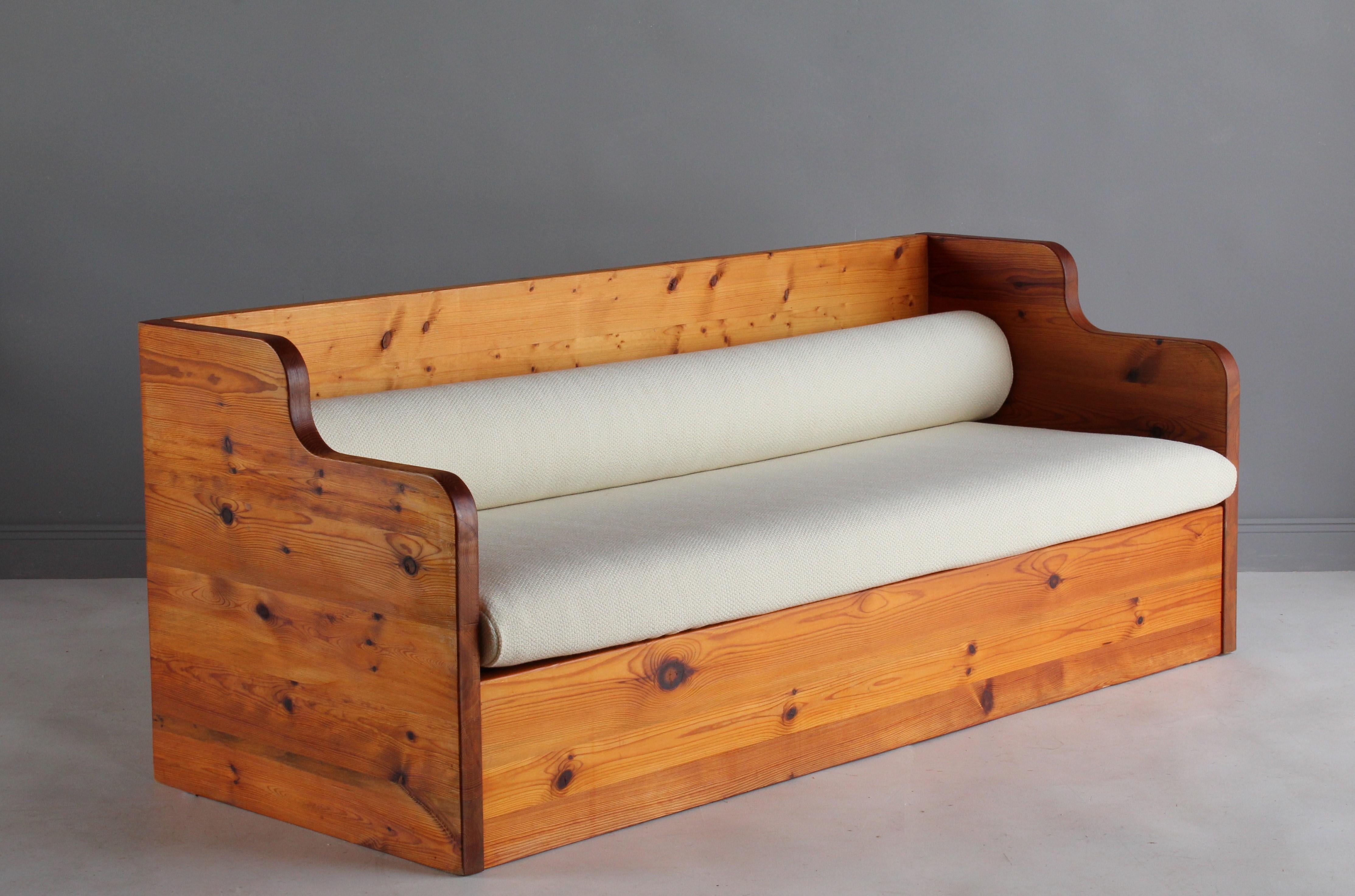 A modern and Minimalist sofa designed in the Swedish sportstuge style. Produced in massive and stacked planks of pine. Produced in the 1970s. The purity of the form highlights the beauty of the material. Seat and back cushion are upholstered in a