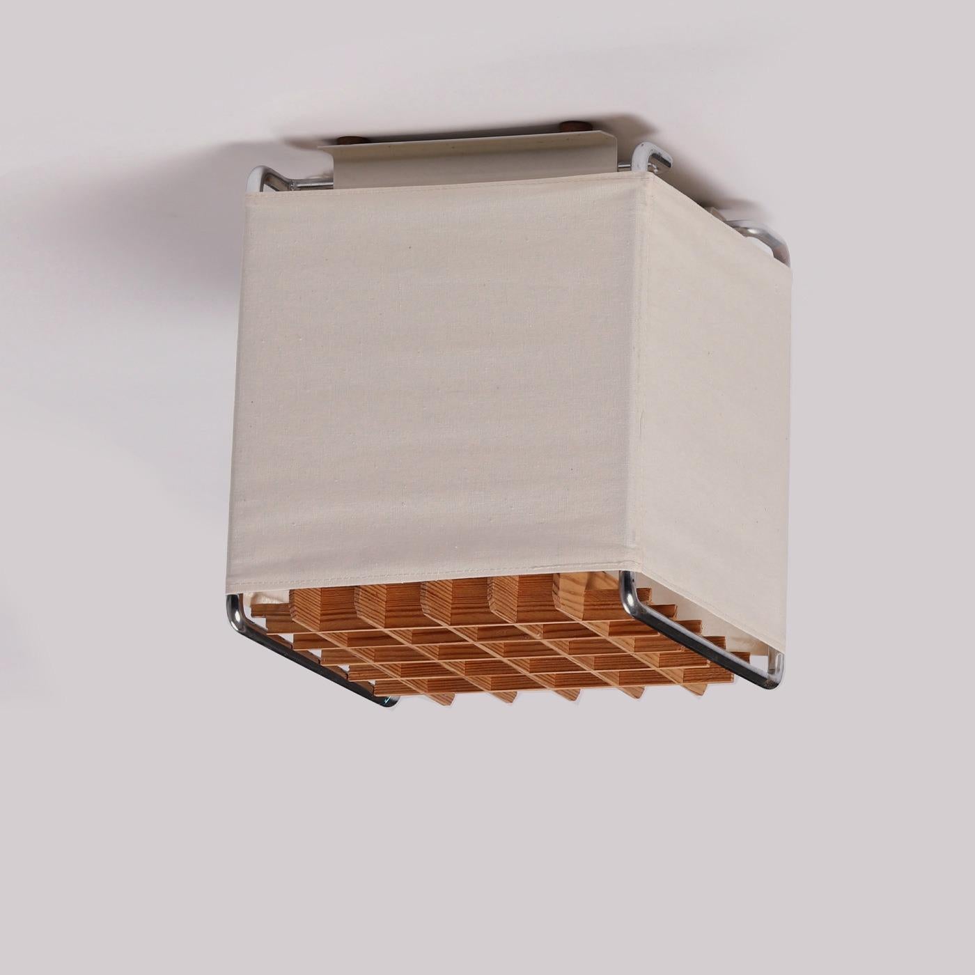 Schwedische quadratische Deckenleuchte, hergestellt von einem schwedischen Tischler, 1970er Jahre. Metall, halbtransparentes Gewebe, abnehmbares Holzgitter. In gutem Originalzustand.

Abmessungen:
Höhe: 23 cm / 9.05 in
Breite: 20 cm / 7.87 in
Tiefe: