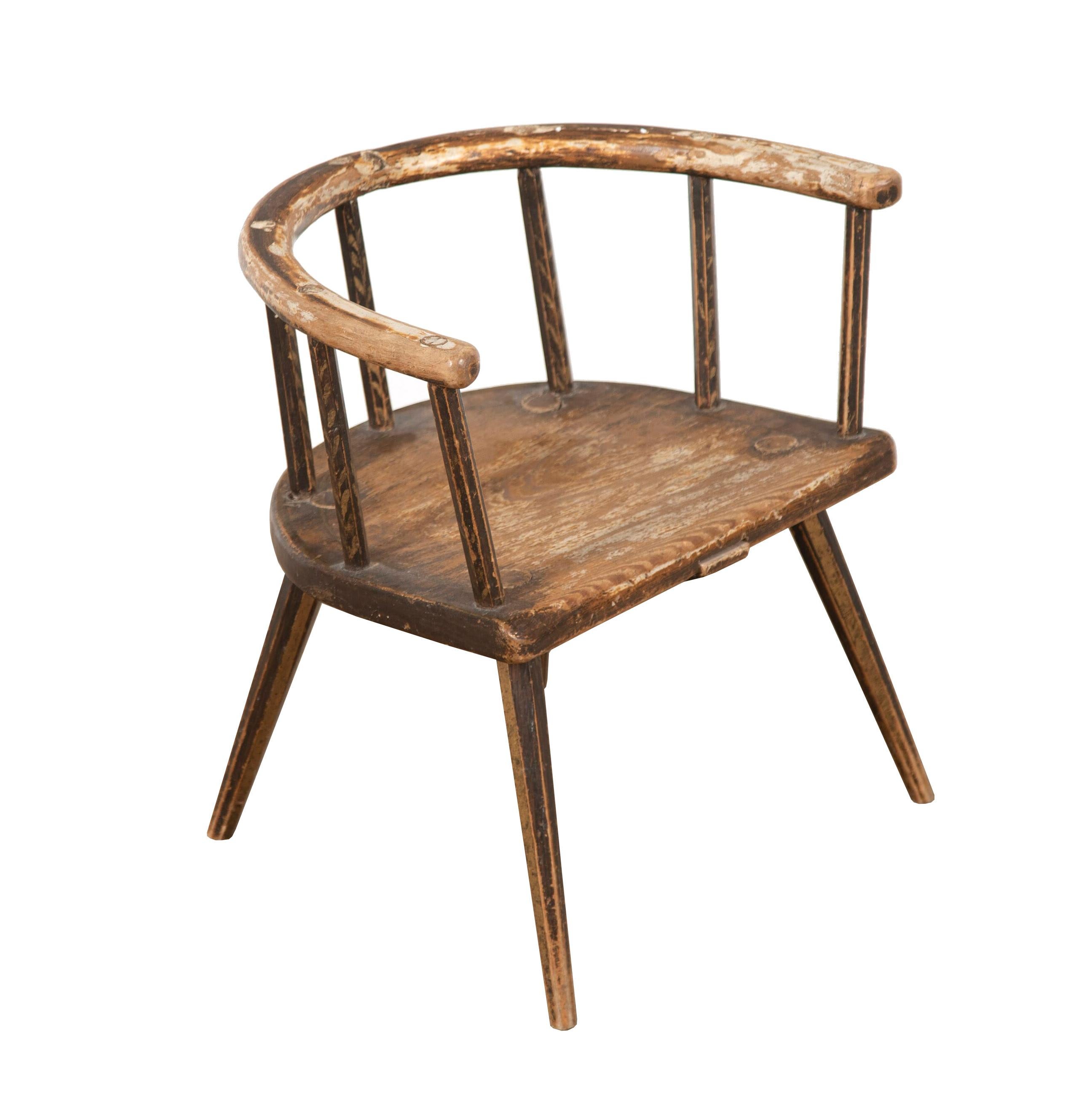 Charming 19th Century stick back child's chair. 
This wonderful chair is made from strong wood and has been painted to create a varnished finish. The paint-work is original to the piece and is beautifully distressed. 
This chair has a great patina