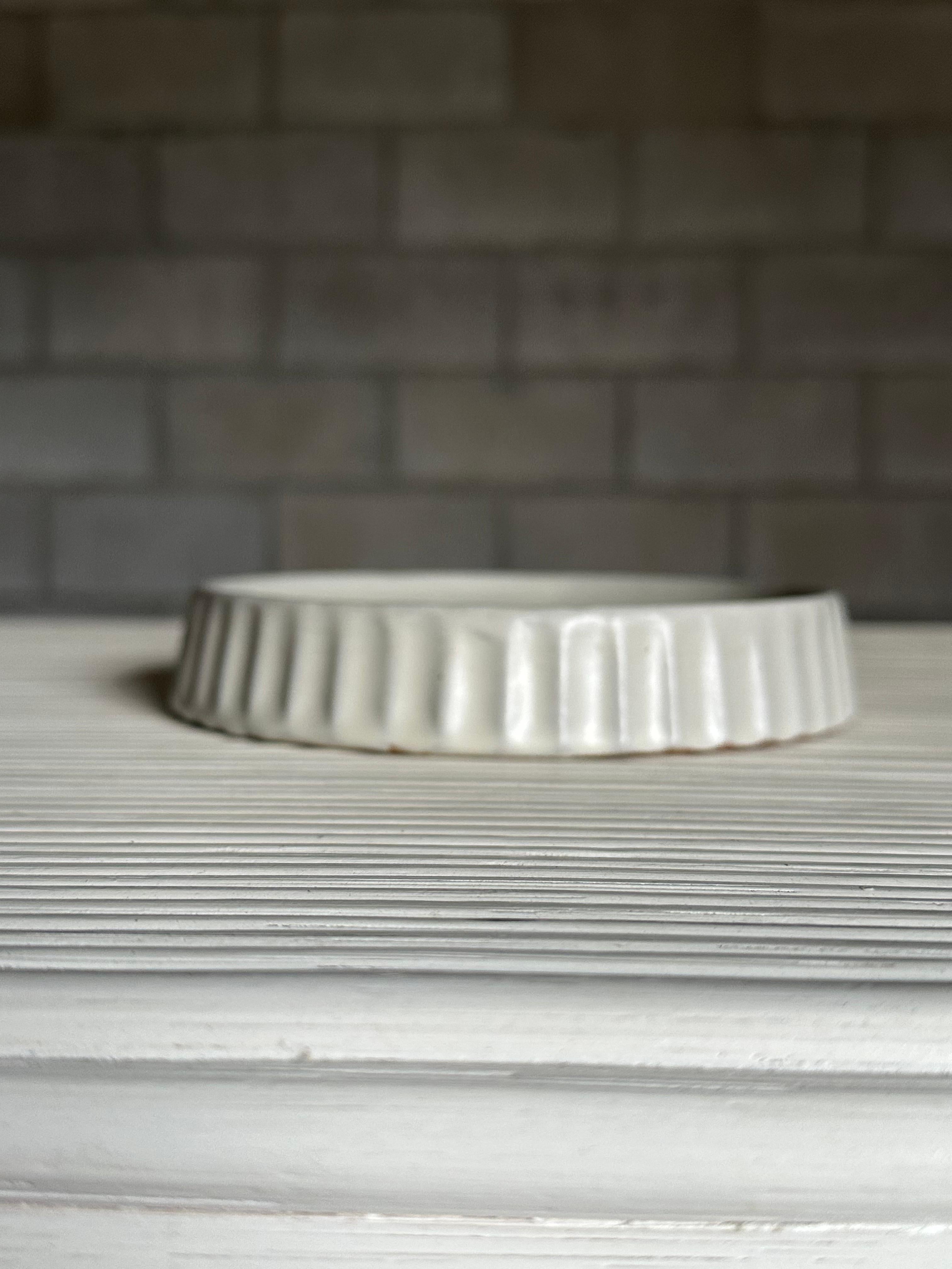 A vintage Swedish modern bowl attributed to Upsala Ekeby. Great flat white cream glaze, and excellent ribbed like pattern on outside edge.
