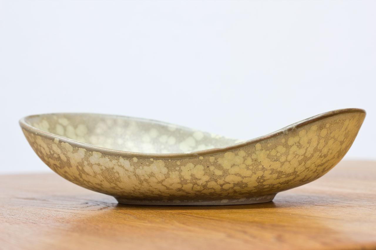 Organic stoneware tray
designed by Carl-Harry
Stålhane for Rörstrand.
Hand thrown in Sweden
during the 1950s. Sand
speckled light yellow
glaze. Incised “R”, three
crowns, Rörstrand with
initials of ceramist. First
line of production.