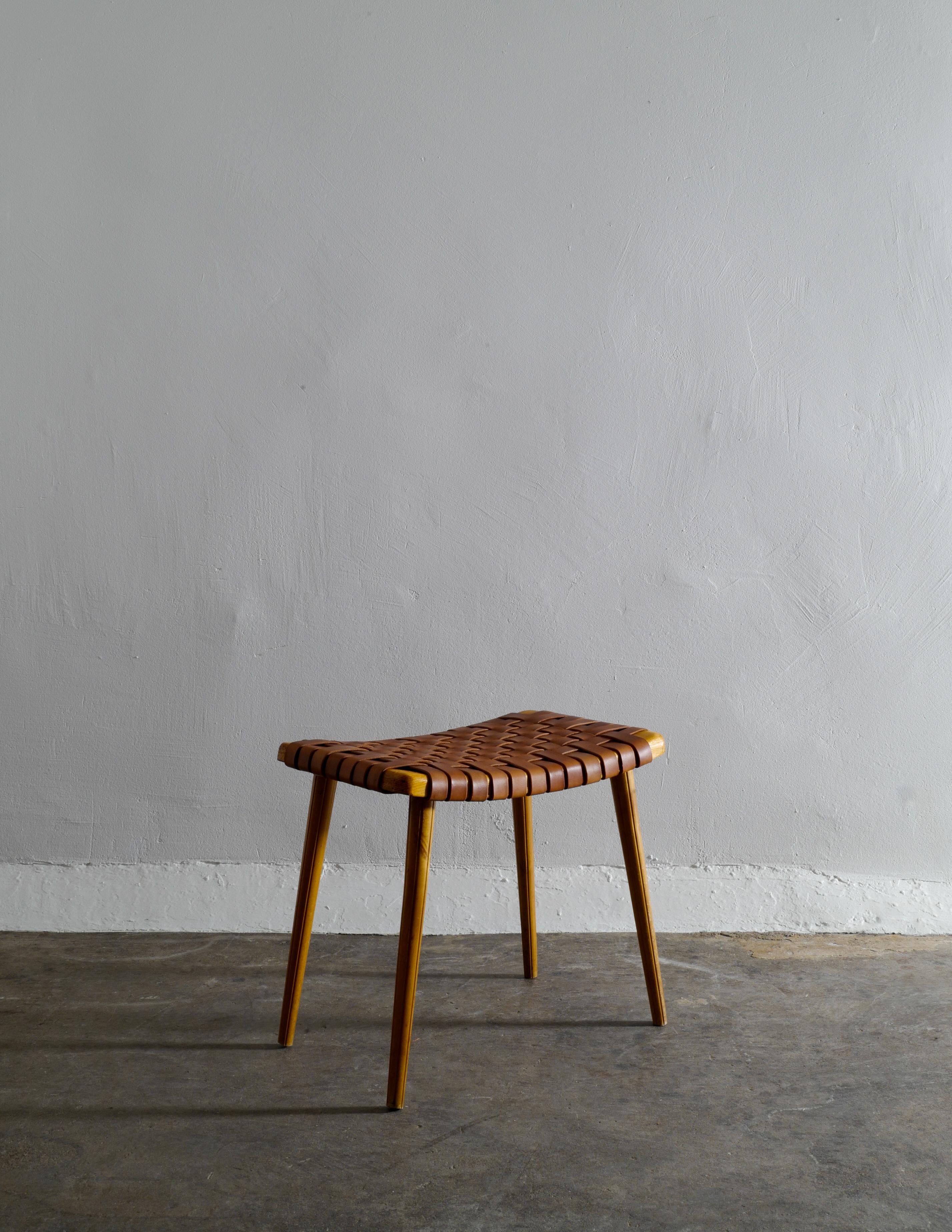 Rare Swedish stool in pine with a cognac brown leather seating. Stable and in good vintage condition showing nice patina and small signs from use and age.