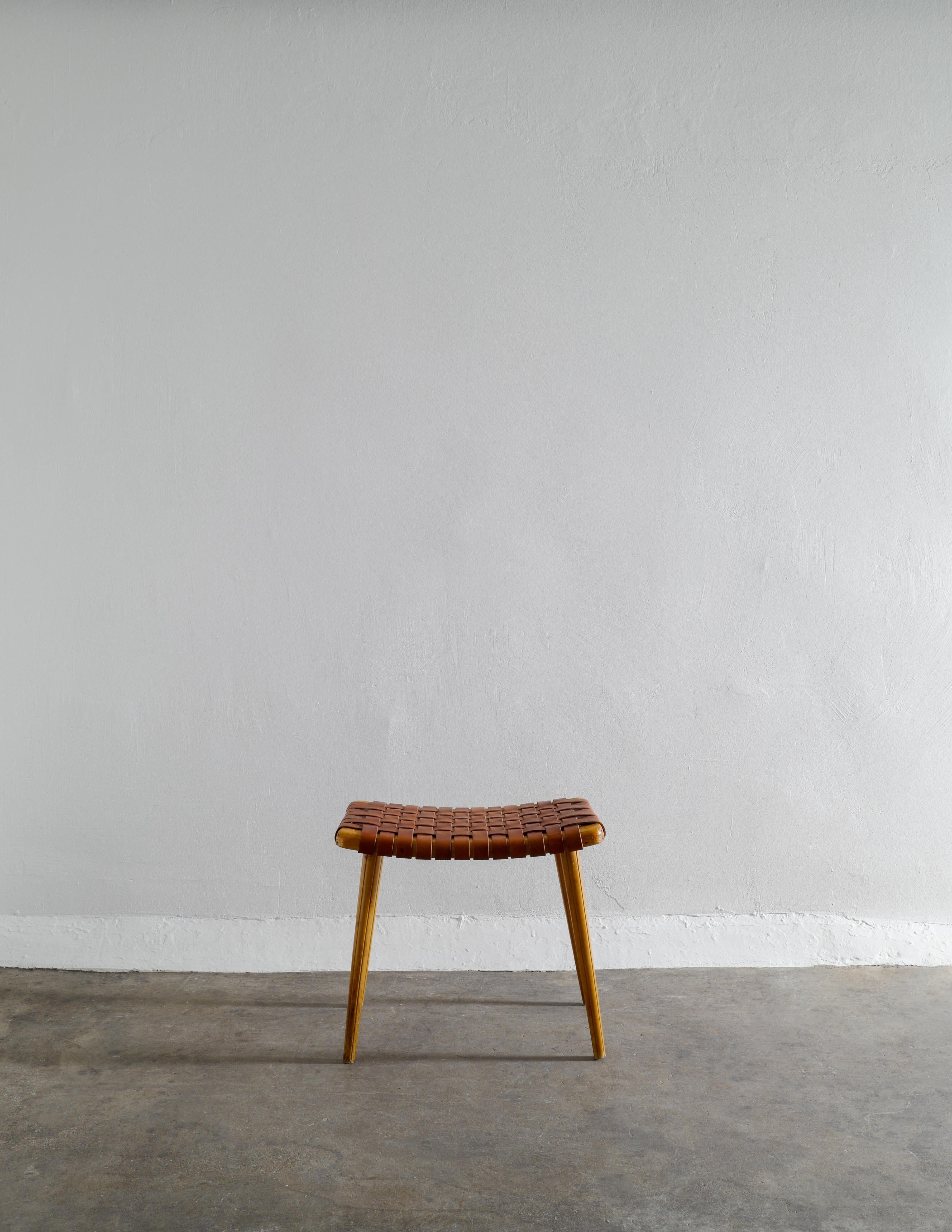 Rare stool in pine and cognac brown leather produced in Sweden in the 1940s. In good vintage condition with small signs from age and use. Leather appears to be newer but has aged beautifully and matches the wood very nicely. 

Dimensions: H: 44 cm