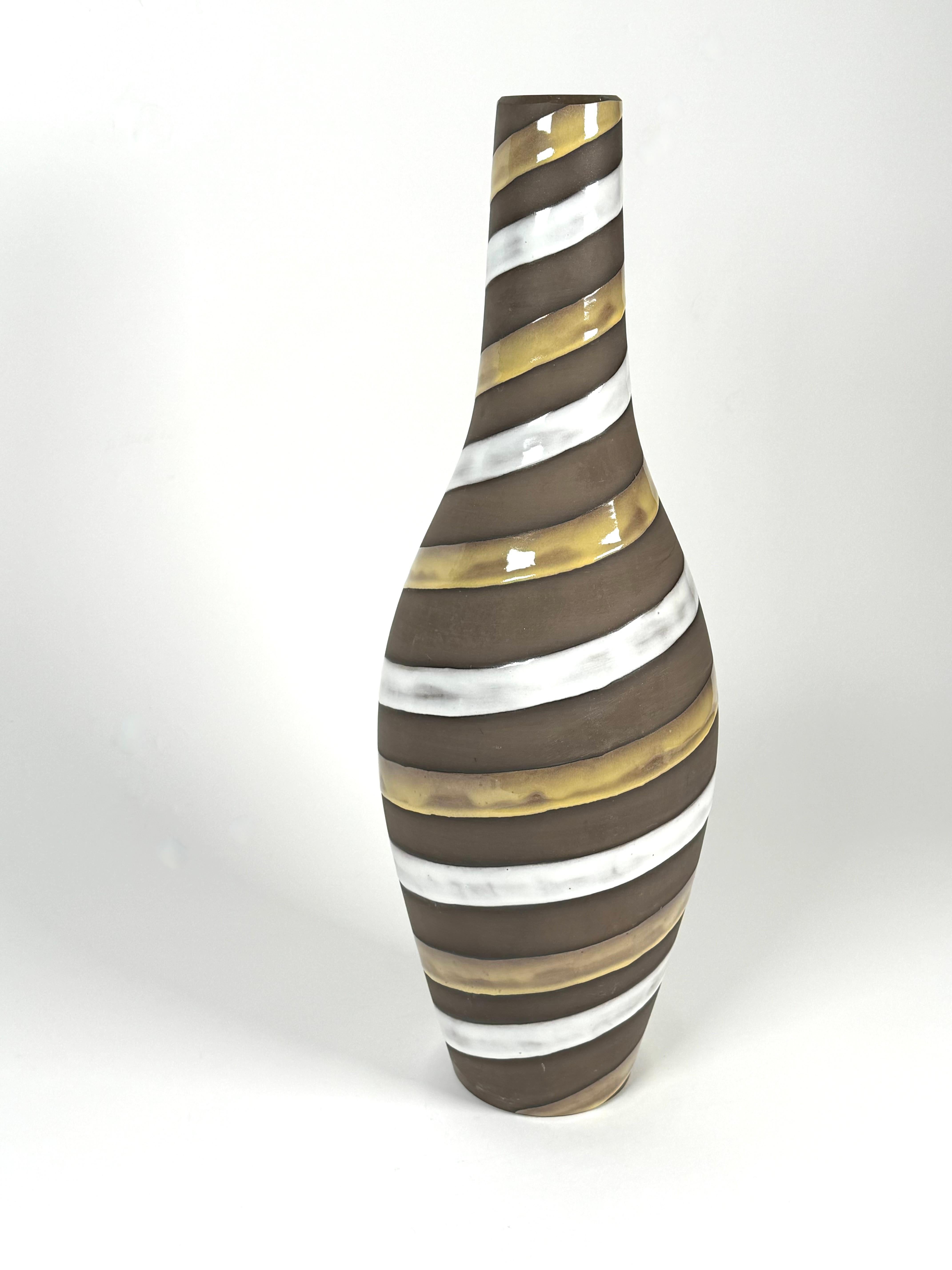 Studio ceramic tapered vase by artist Ingrid Atterberg (1920-2008) of Sweden. A tapered form with striped glazes running from the top to bottom of the vase, with an off white glaze and an earthy yellow glaze embellishing the soft earth toned mat