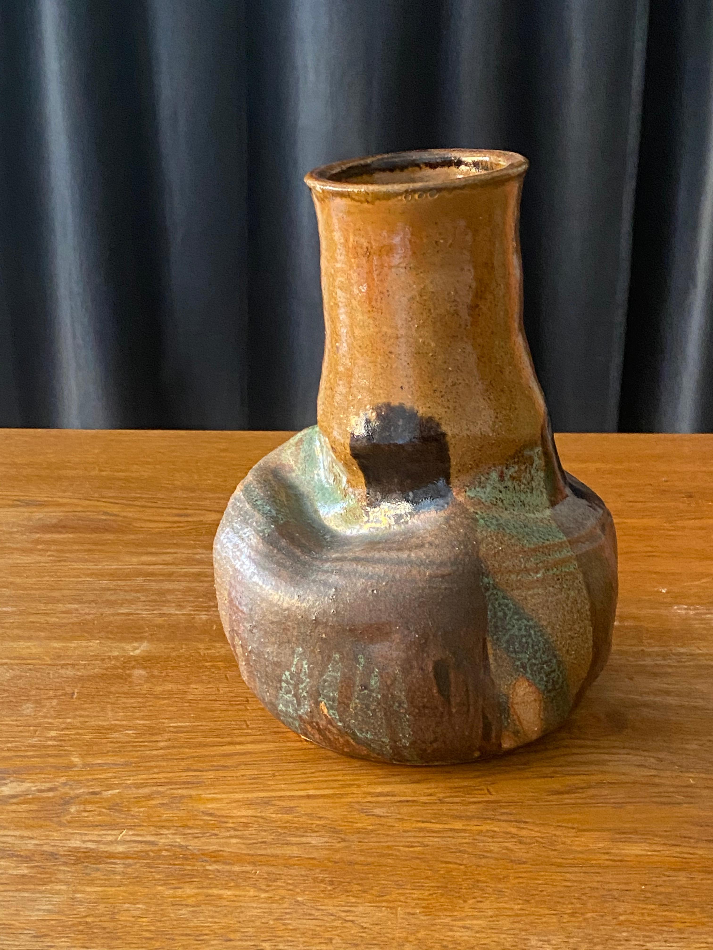 An organic freeform vase, hand-sculpted and hand painted, signed by the artist and dated 1978. 

Painted in an abstract green / brown / black motif, complementing the form in a style similar to Peter Voulkos, Hans Cooper or Lucie Rie. 

 