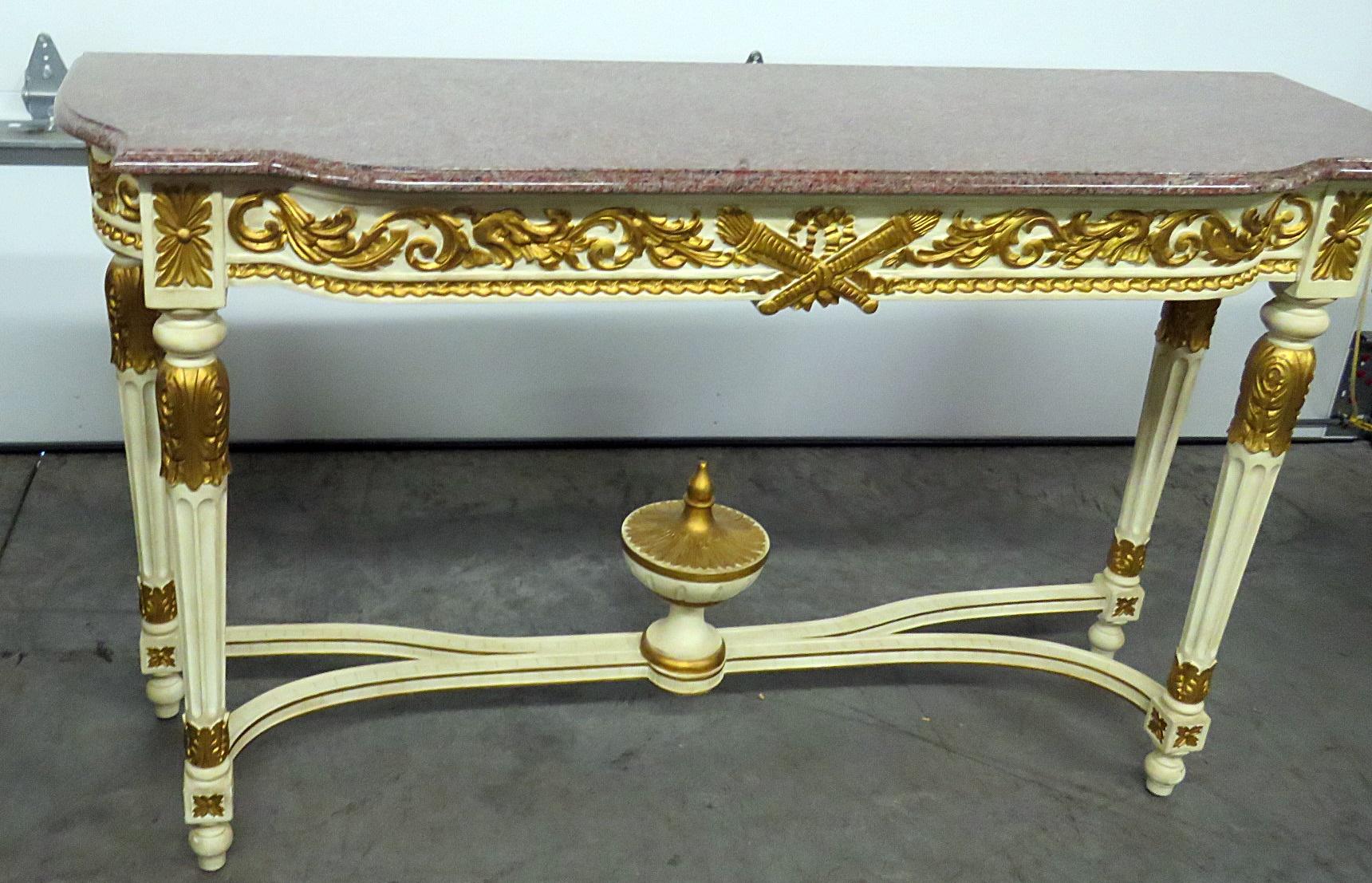 This is a gorgeous gilded and creme painted console table. The table features bright gold leaf over a painted ground and is in excellent vintage condition. This is quintessential Louis XVI styling and will add opulence to any home.