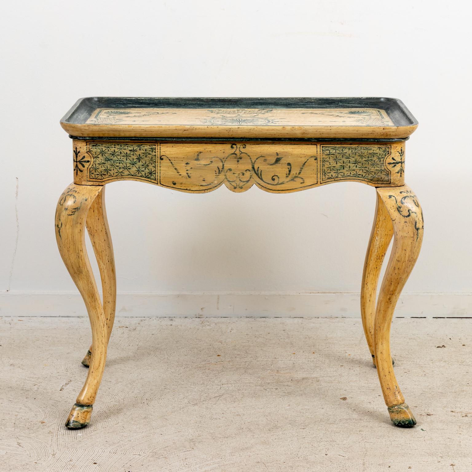 Swedish style tea table, hand painted throughout with motifs of scallop shells and scrolled foliage as seen on the tabletop, curved apron, and cabriole legs. Please note of wear consistent with age including distressed finish to the paint, minor