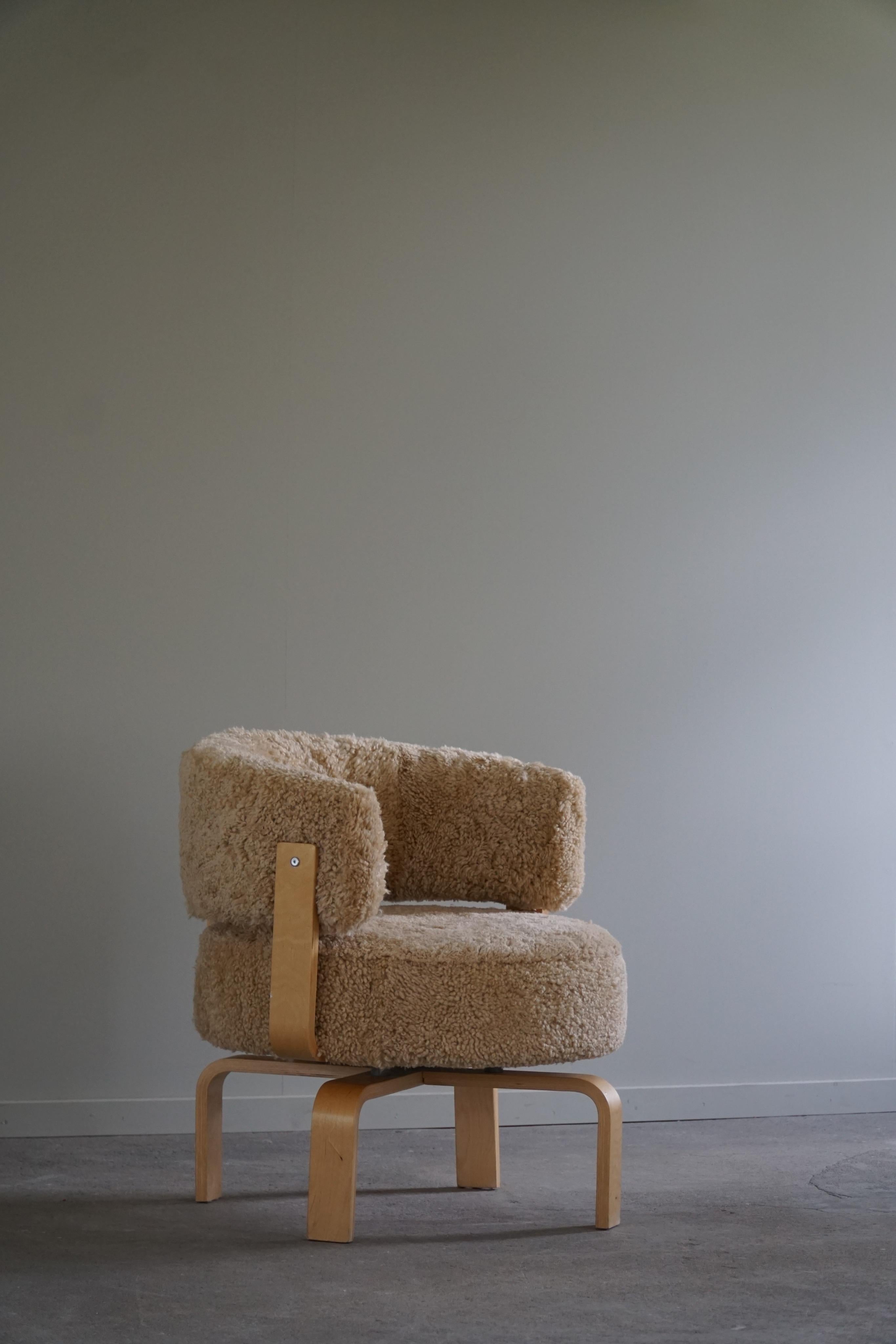A lovely cosy 360 degree swivel armchair, reupholstered in a great quality shearling lambswool, frame and legs made of bented beechwood. Designed by Carina Bengs for Ikea in 2004. Model “Fidene”, out of production today. 

Sold individually and as