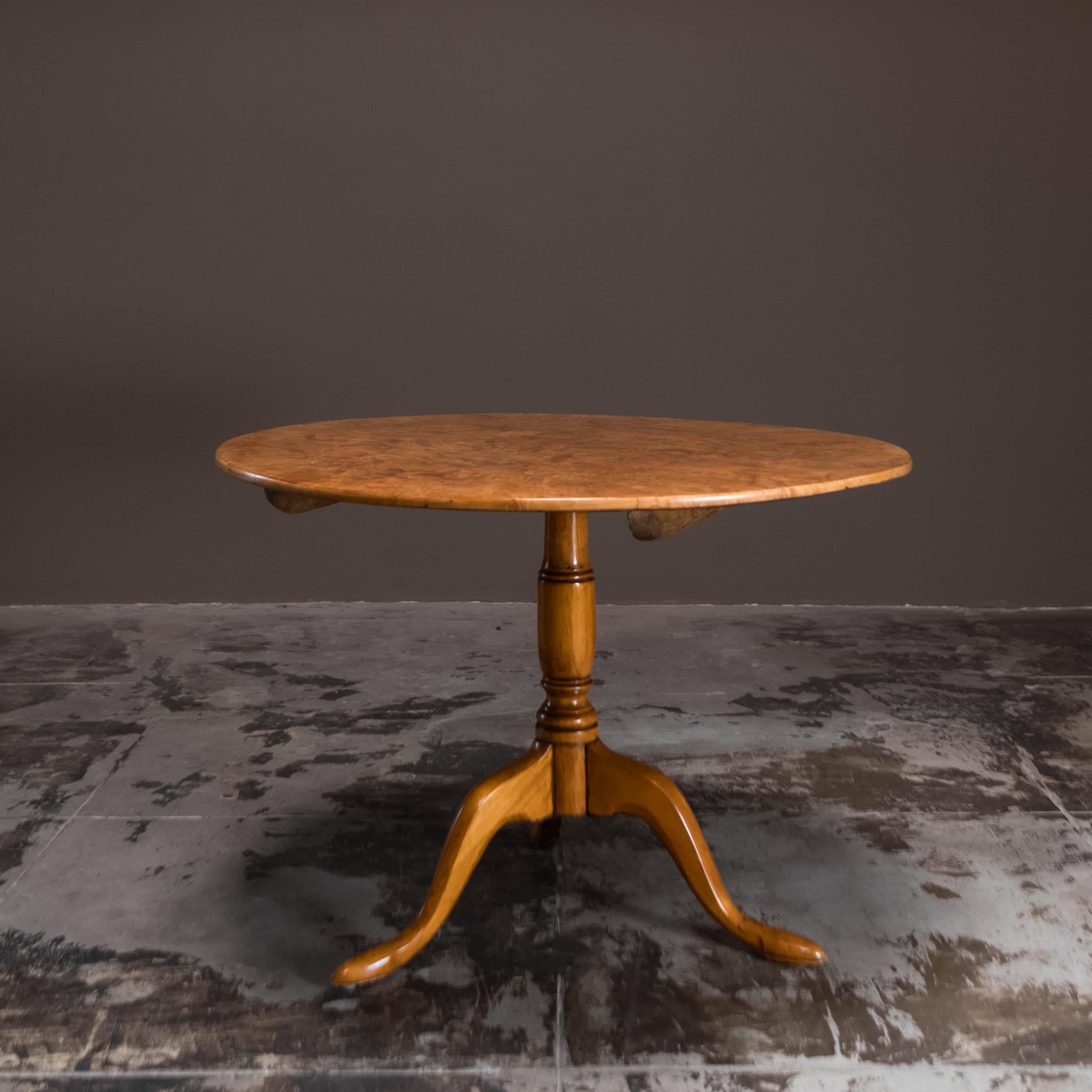 Vintage Swedish table, crafted from birchwood root veneer. The tabletop showcases a patchwork of golden burl veneer. This exceptional table draws inspiration from 18th-century Swedish Gustavian designs with its tilt-top feature and intricately