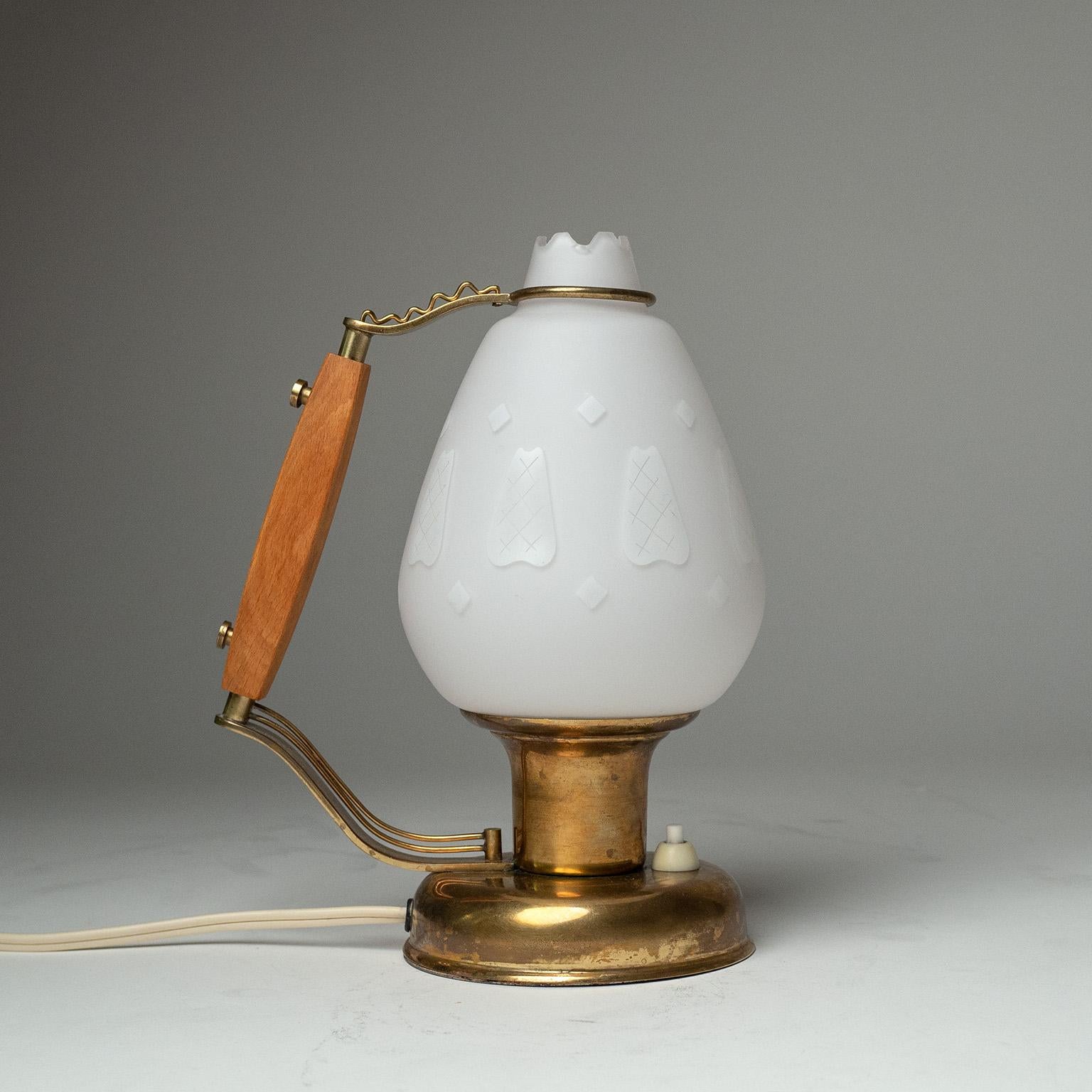 Delightful Swedish table lamp from the 1940s. Brass base and details with a beech grip and satin glass diffuser which has enameled decorations.