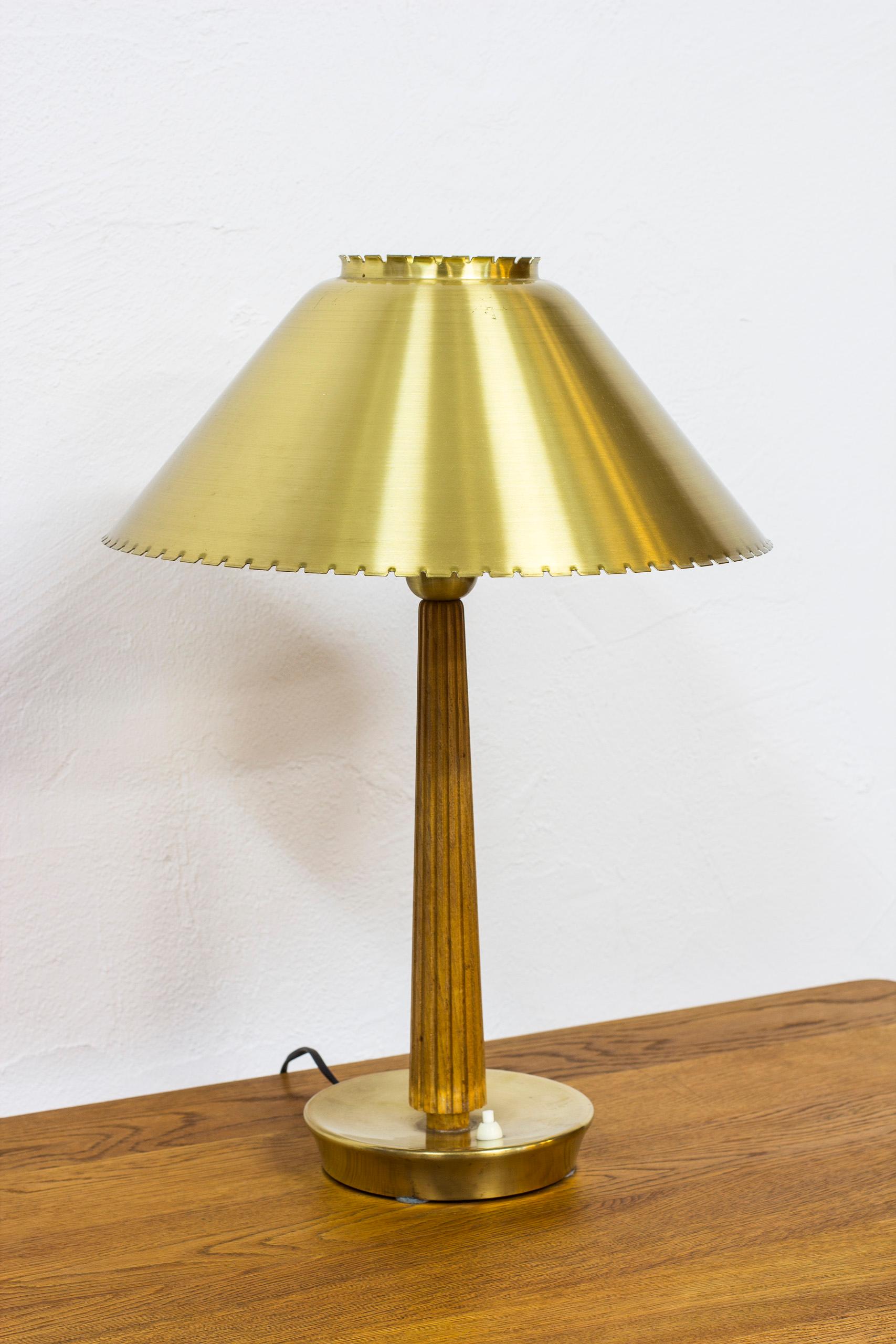 Table lamp produced by ASEA Belysning in Sweden during the 1950s. Most likely designed by Hans Bergström. Made from solid brass and oakwood, with i white opaline glass shade. Light switch on the base in working order. Very good vintage condition