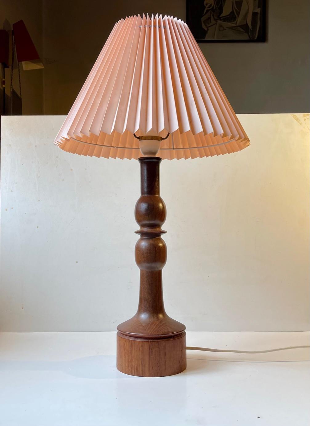 A wellmade Table lamp in solid teak and walnut. Engine turned and stacked making a subtle stylish pattern at the base. Anonymous Swedish cabinetmaker circa 1960 in a style reminiscent of Luxus and Severin Hansen. Measurements: Height: 54 cm with the