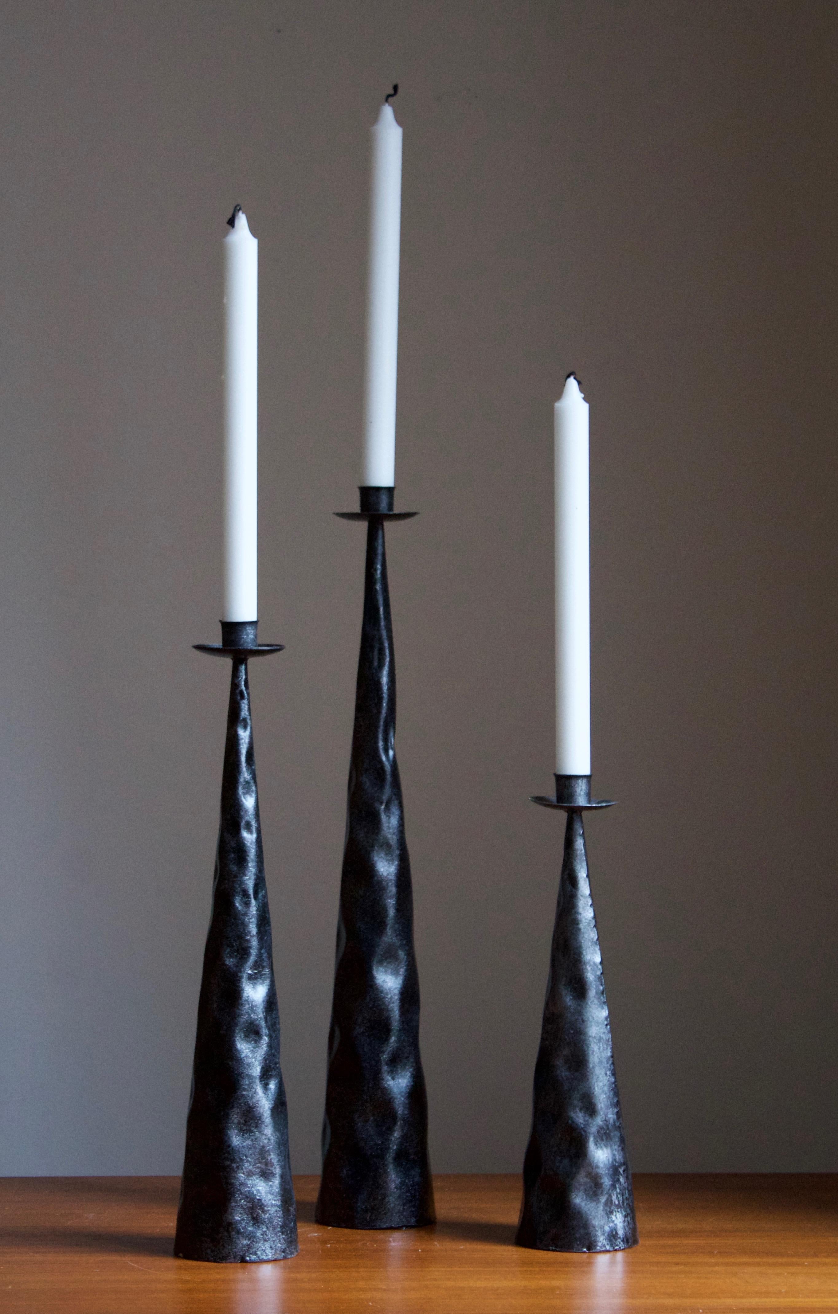 A set of three candlestick holders. Produced in Sweden, c. 1970s. In thin and light hammered and welded sheet metal. Painted.