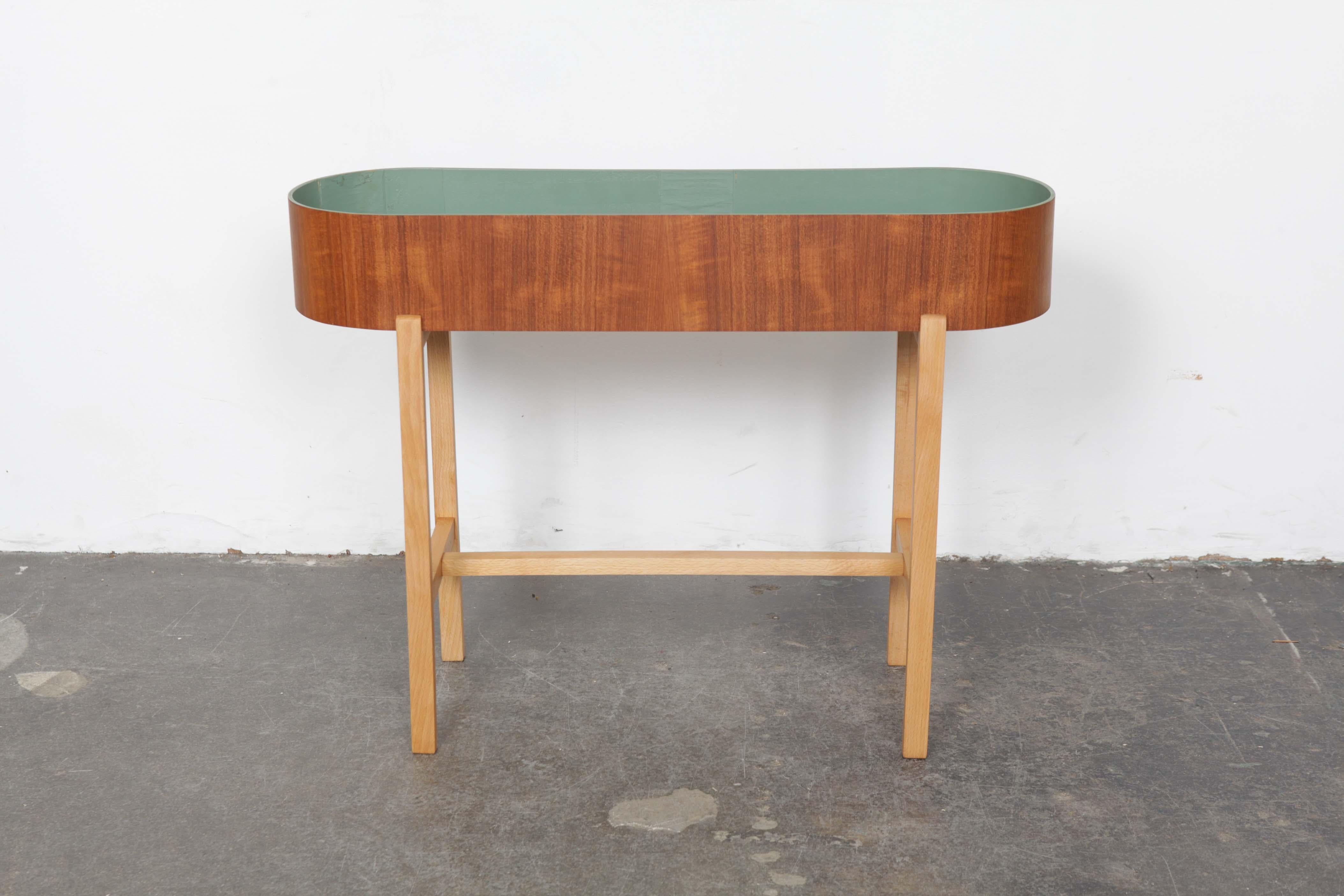 Newly refinished wonderful Swedish elliptical teak planter on an beech base with a green planter wall, and metal 'floor', made circa 1960s.