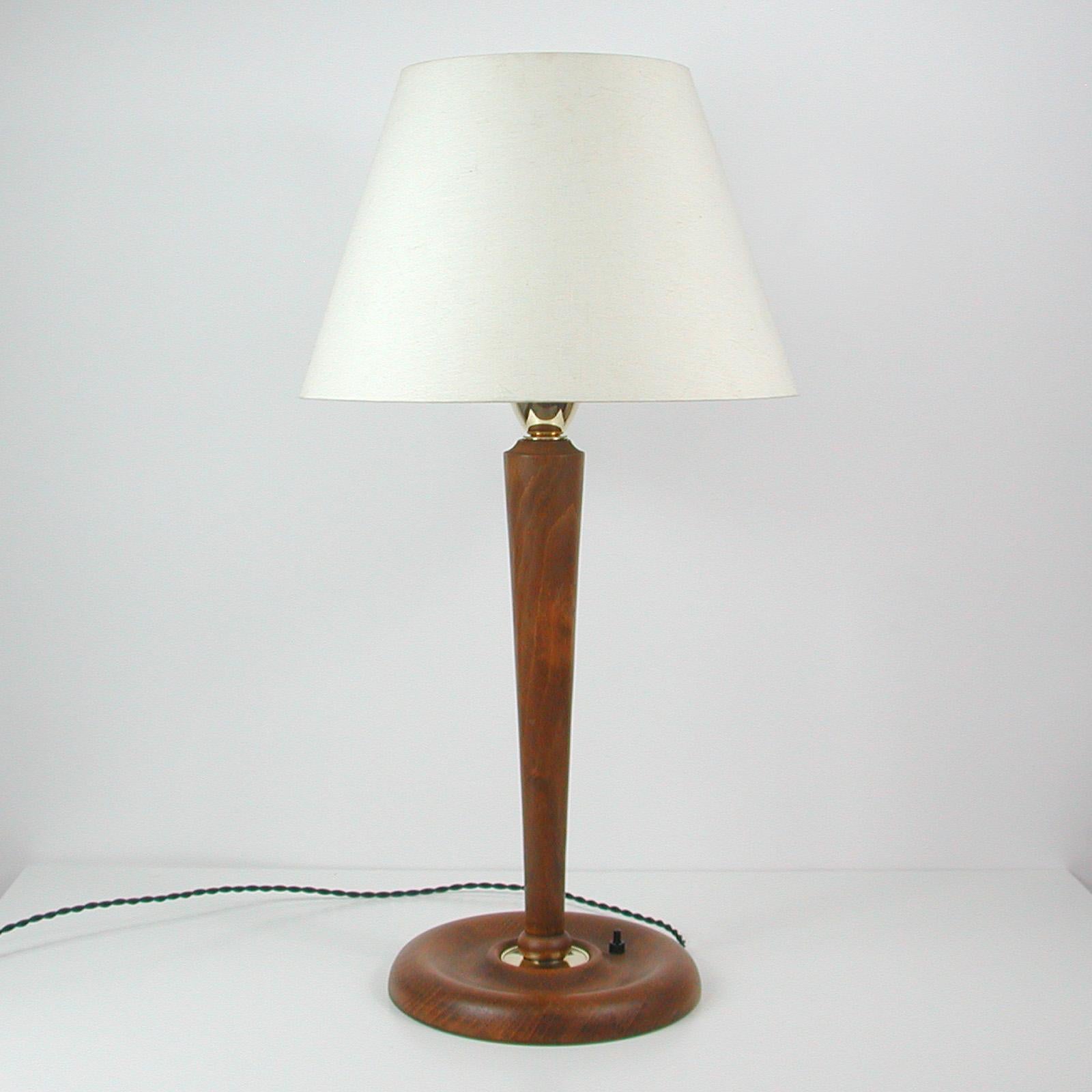 This large and elegant Scandinavian table lamp was designed and manufactured in Sweden in the 1940s. It features a teak base with brass details and requires one E27 bulb.

An awesome late Art Deco design in very good original condition with minor