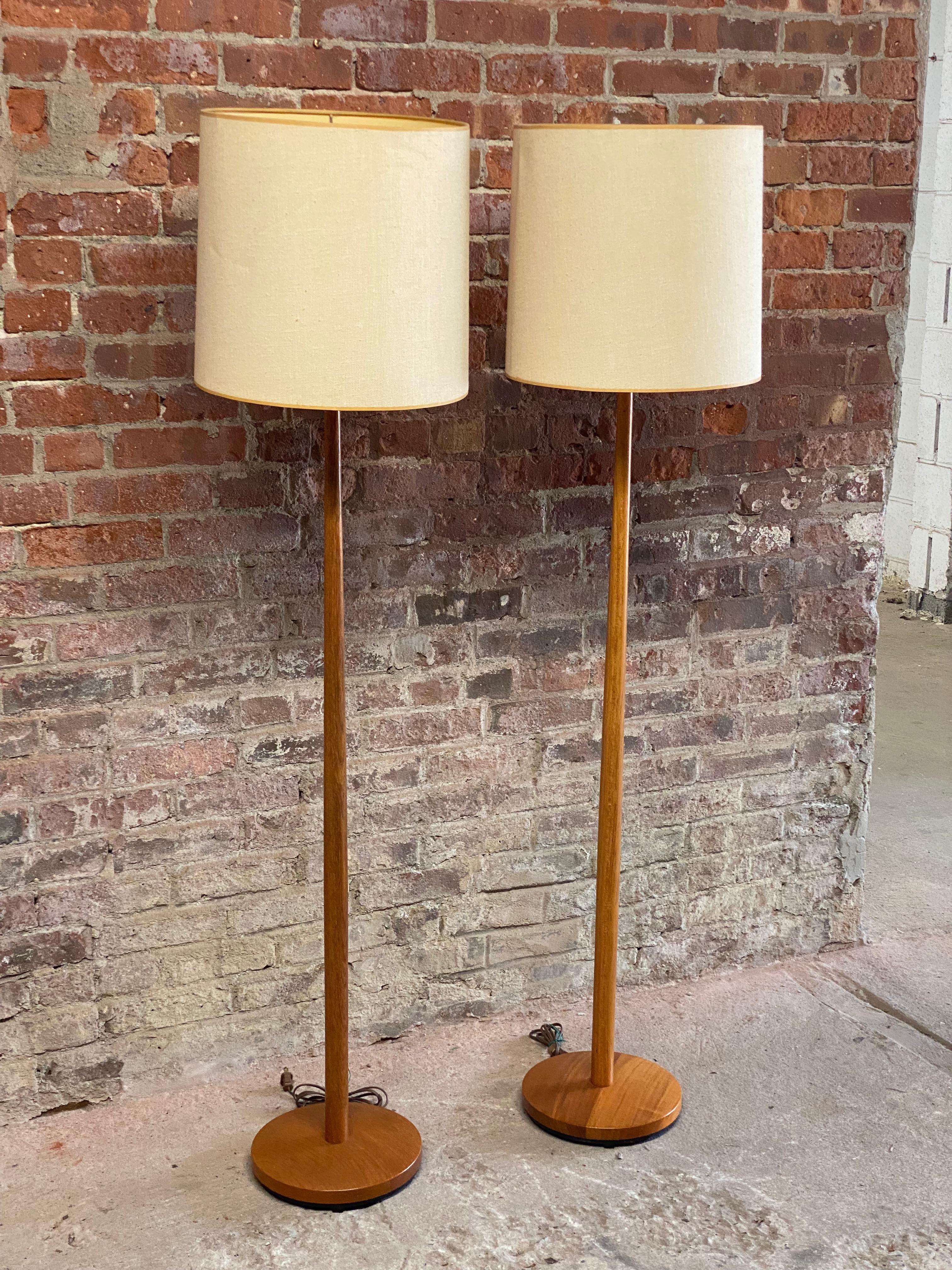 A beautiful pair of solid teak Swedish floor lamps. Simple and elegant design. Weighted iron bases, tapered shaft. Signed with metal tag on the bottom of each lamp. Purchased from a great Scandinavian Modern shop, Contemporary Trends, Ithaca, NY,