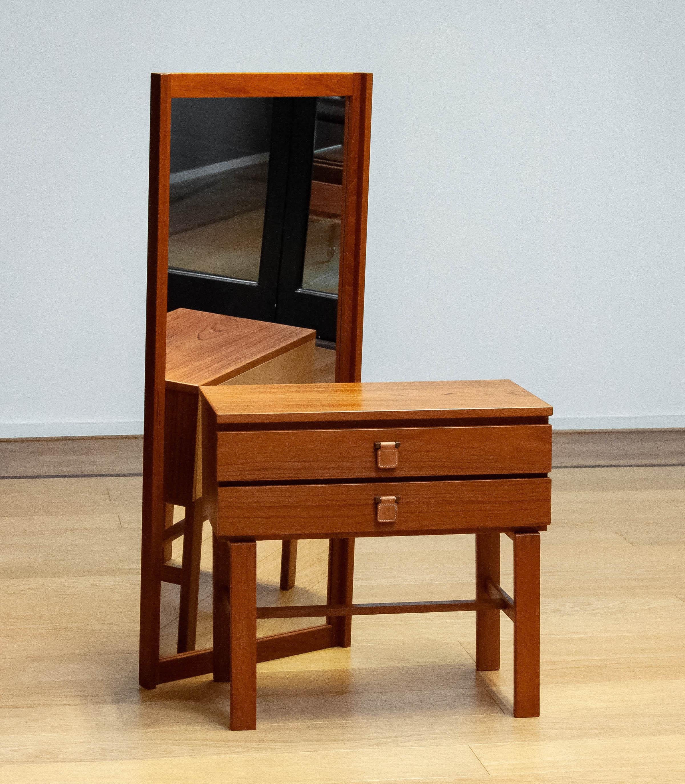 Magnifique commode scandinave Moderen avec miroir assorti de la série Charmant en teck conçue par Sigurd Göransson pour le fabricant Fröseke Nibrofrabriken en Suède, 
Le meuble comporte deux tiroirs avec des suspensions en laiton et en cuir. Les