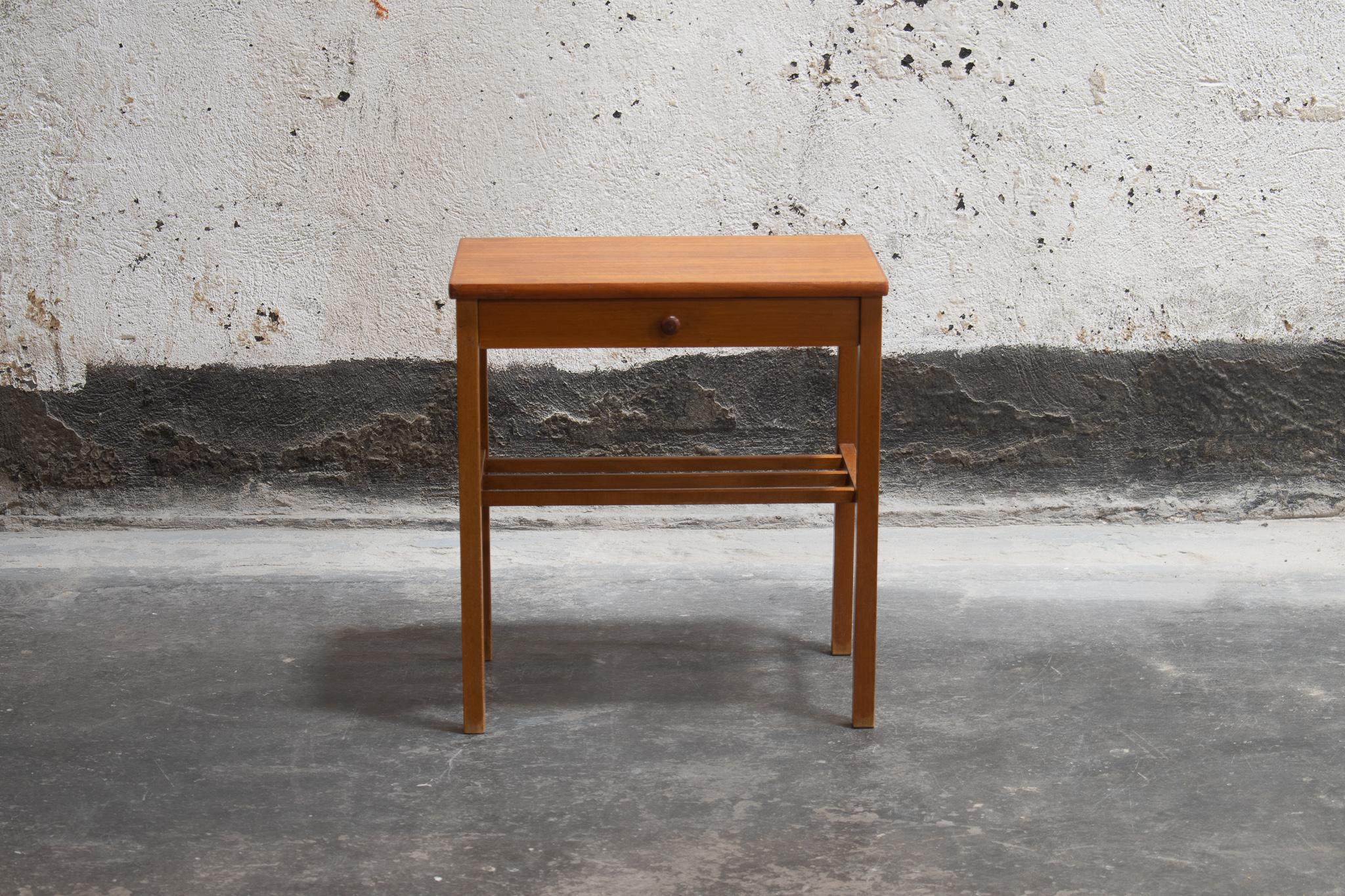 Mid-Century Modern nightstand or side table from Sweden, circa 1960. This Scandinavian teak side table has a small drawer with a round pull and slat shelf. This Swedish Modern table is perfectly sized for use as a Minimalist bedside table or as a