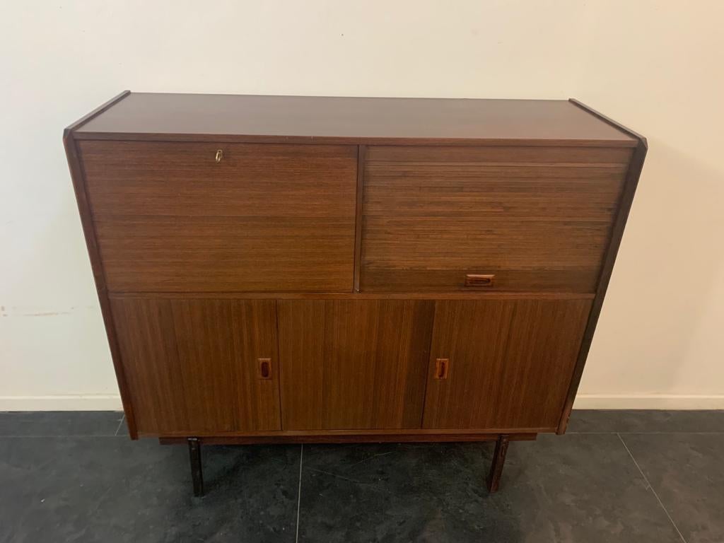 Highboard swedish style 50's in teak. Lower part has 3 hinged doors, above 2 compartments one with flap closure and one with shutter.