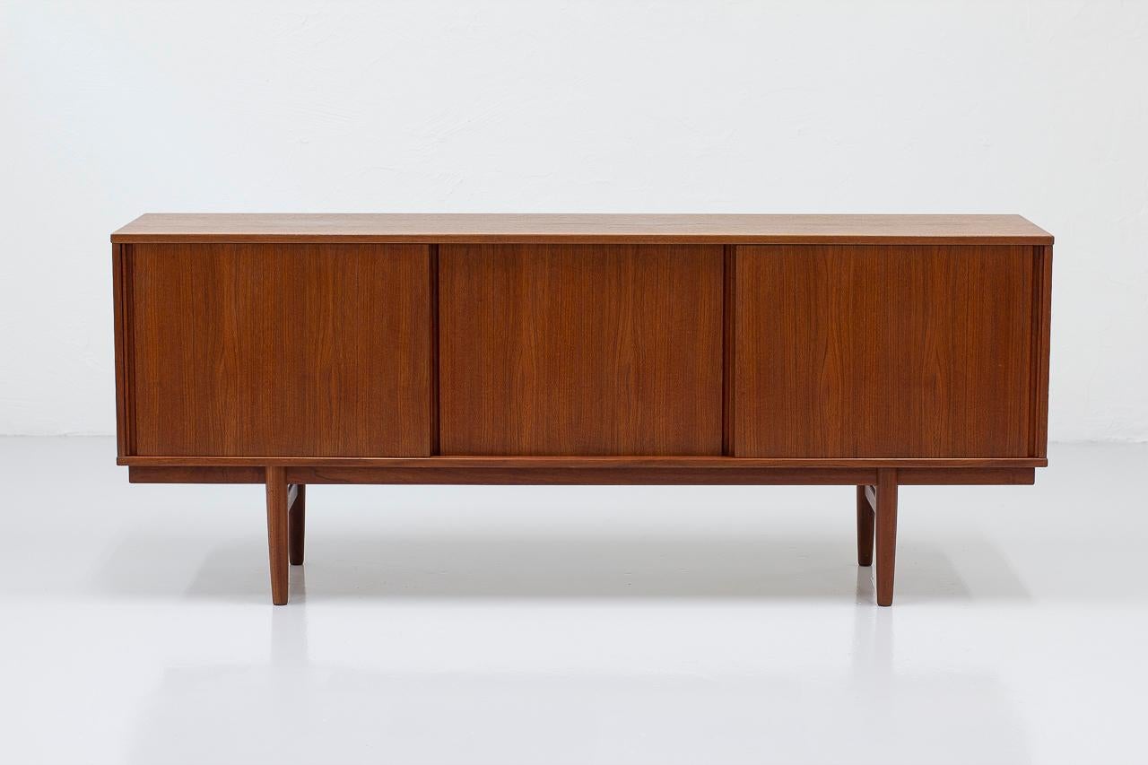 Beautiful teak sideboard with sliding doors from unknown maker, most likely
Swedish from the 1960s. Made from teak featuring shelves and drawers in birch.
Very good quality in the making.

