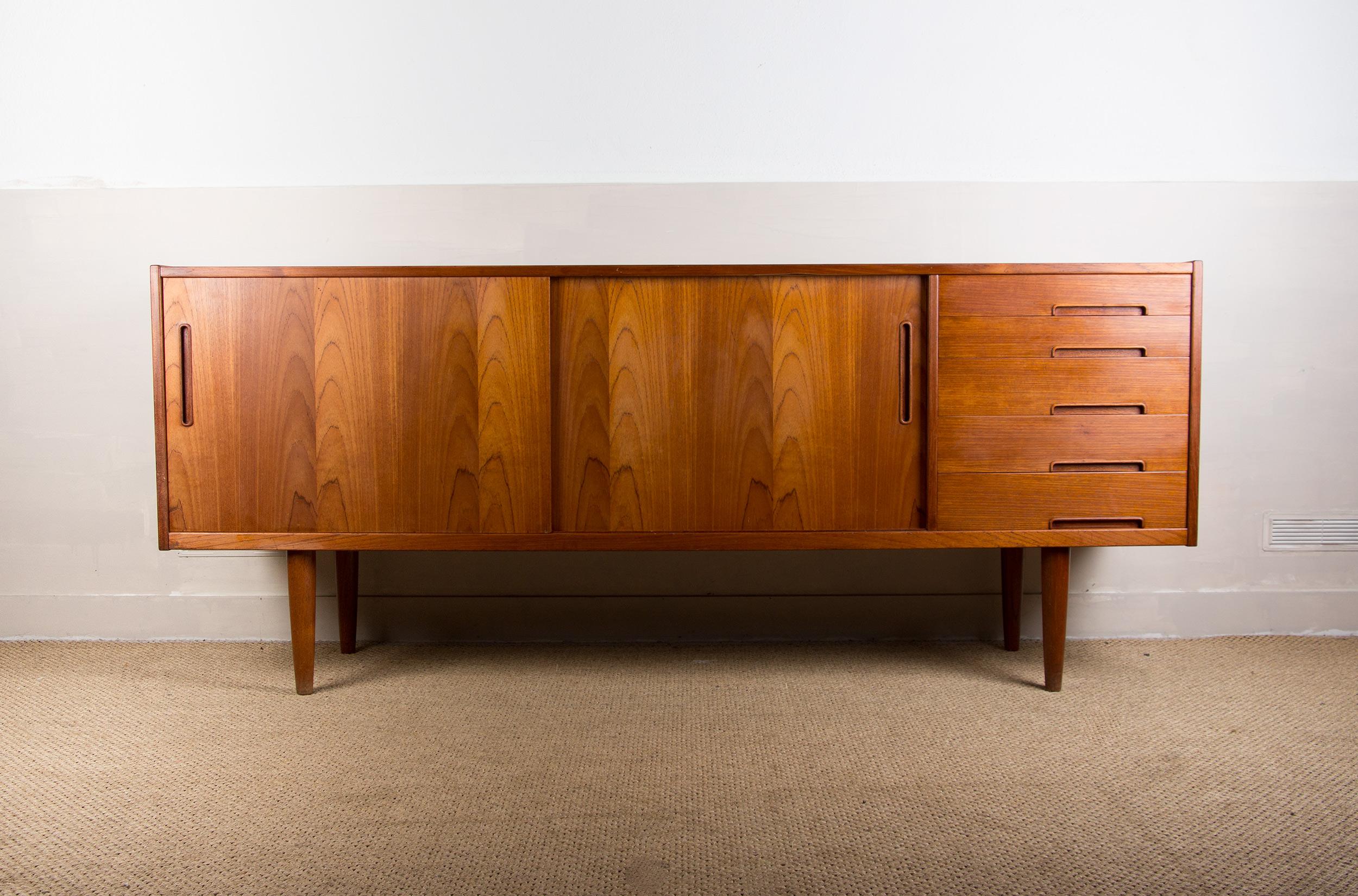 Beautiful Scandinavian sideboard in the sober and modernist style typical of this Designer. Composed of 2 sliding doors on the right side and 5 drawers on the left, it offers a large storage capacity and can fit into a small space. Very good build