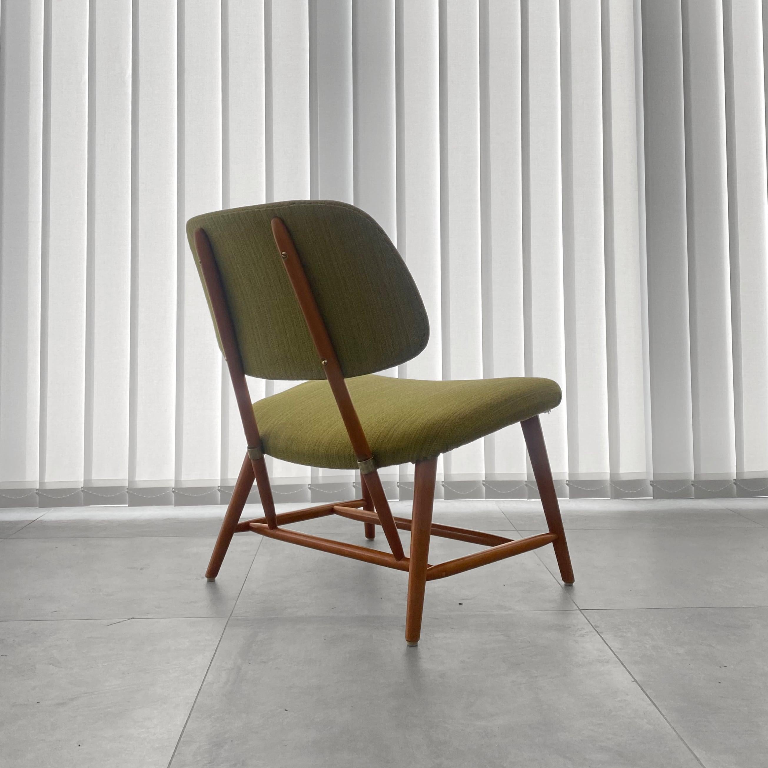 A TeVe lounge chair, designed by the Swedish architect Alf Svensson in 1953 for the manufacturer Ljungs Industrier (Dux). Crafted from solid beech with brass details and featuring original textile upholstery in a soft shade of green. This unusually