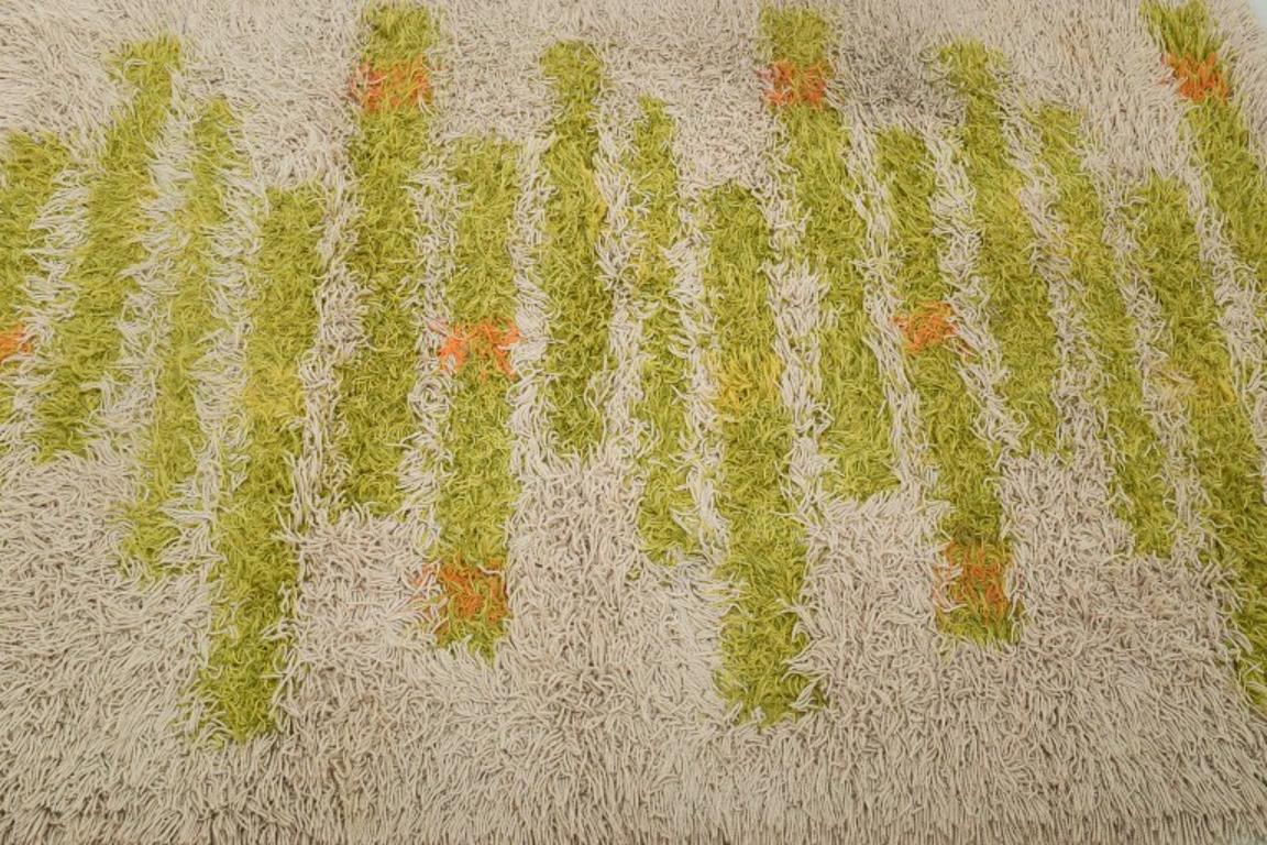 Swedish textile designer. Blekinge-rya. Large carpet in pure wool.
Modernist design. Green, orange, and white colors.
1960s.
Model: 