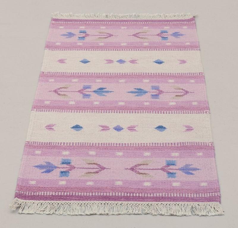 Diseñadora textil sueca.
Alfombra tejida a mano en pura lana. Técnica Rölakan.
Motivos florales. Colores rosa y azul.
Mediados del siglo XX.
En excelente estado, con mínimas señales de uso.
Dimensiones: 138 cm x 66 cm.