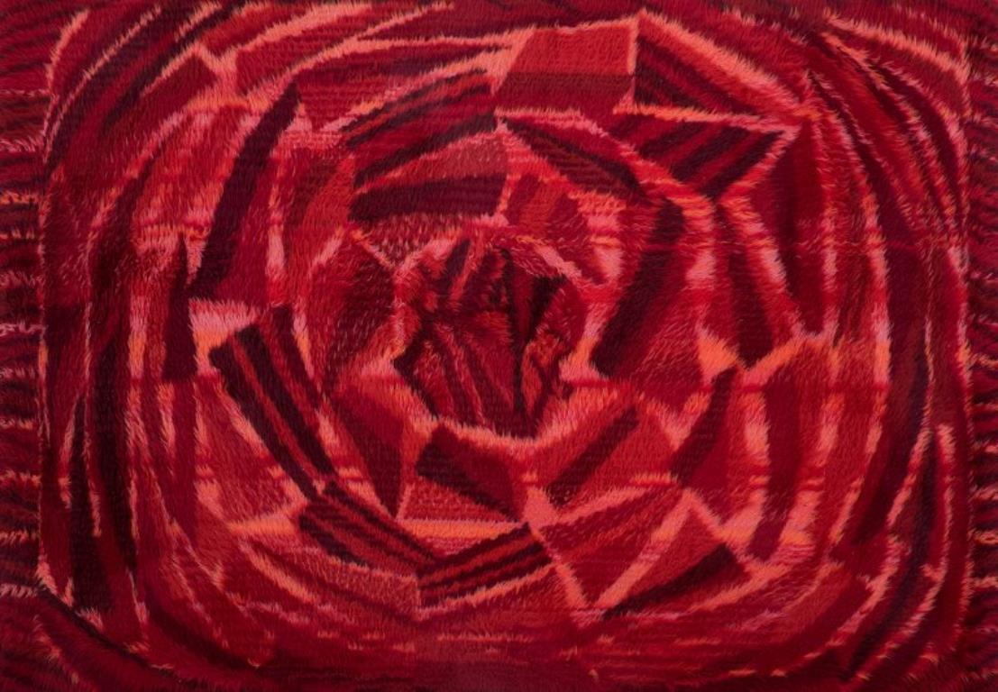 Swedish textile designer. Handmade rya carpet of pure cotton. 
Red, orange, and pink colors.
Retro style.
1960s/70s.
In excellent condition.
Dimensions: 193 cm x 135 cm.