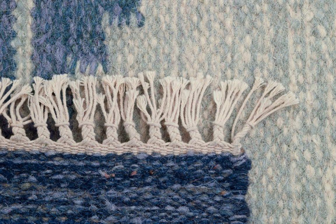 Wool Swedish textile designer. Handwoven carpet in pure wool. Gray and blue colors.