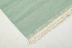 Swedish textile designer. Handwoven Rölakan rug in muted green tone.