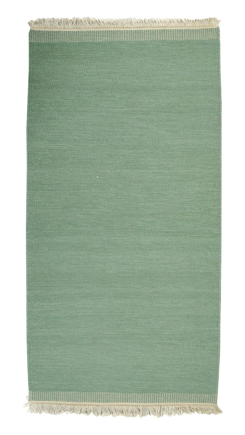 Swedish textile designer. Handwoven Rölakan rug in muted green tone.