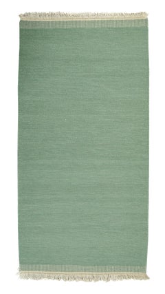 Swedish textile designer. Handwoven Rölakan rug in muted green tone.