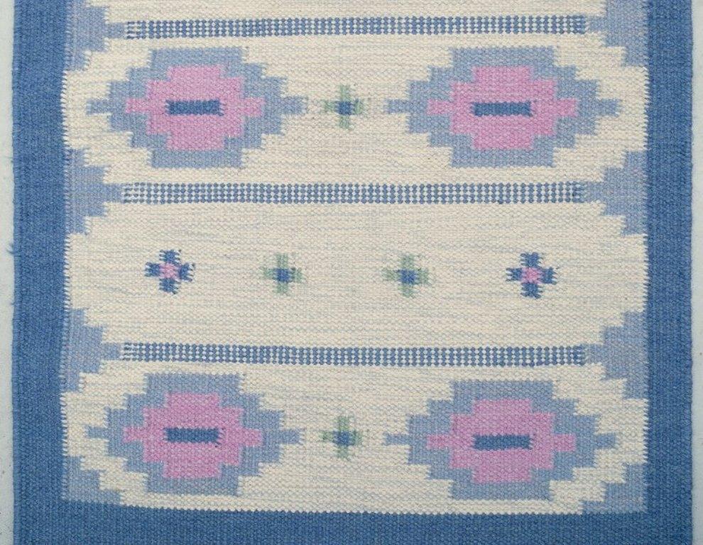 Designer tessile svedese.
Runner intrecciato a mano in pura lana. Tecnica Rölakan.
Motivo geometrico.
Colori blu, rosa e bianco.
Metà del XX secolo.
Condizioni perfette.
Dimensioni: 257 cm x 83 cm.