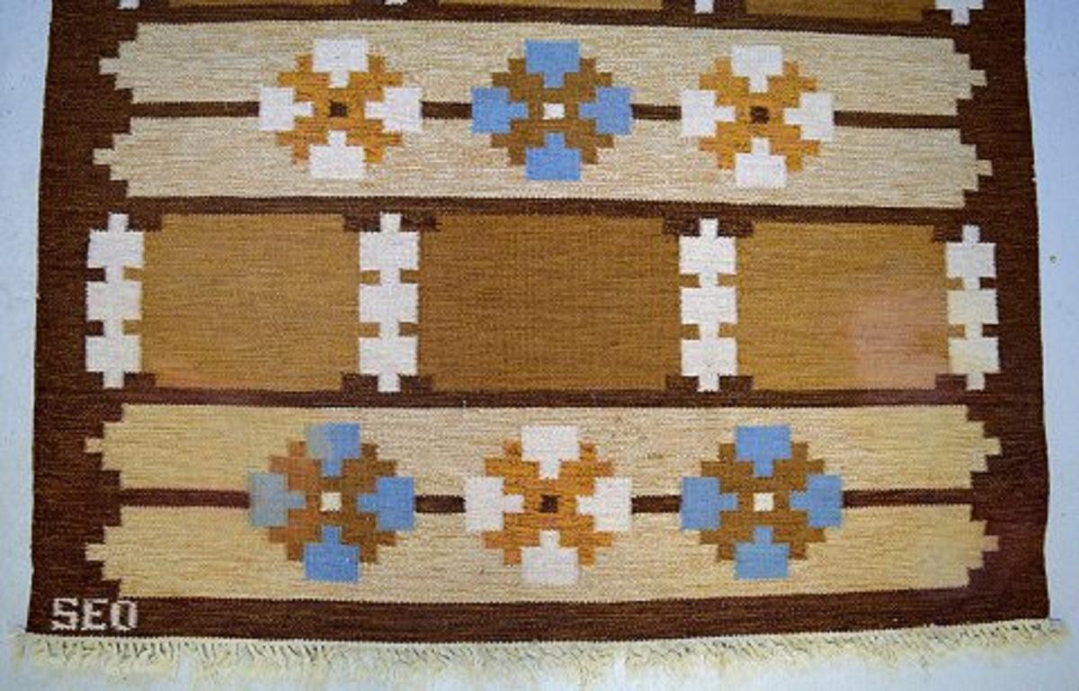 Swedish textile designer. 
Large handwoven Rölakan rug in pure wool with geometric fields and clean lines in brown, blue and sand-colored shades,
mid-20th century.
Measures: 230 x 165 cm.
In excellent condition.
Signed in monogram.