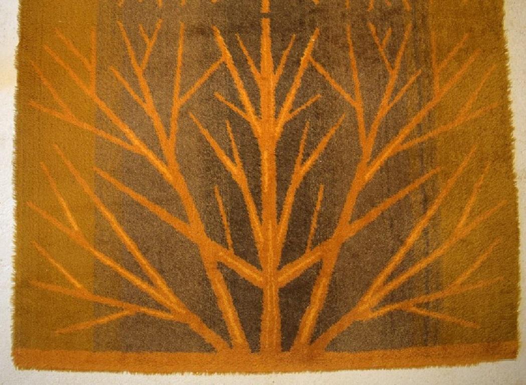 Swedish textile designer. 
Large hand-woven RÖLAKAN rug in pure wool decorated with trees in beautiful autumn colors. 
1960/70s.
Measures: 240 x 170 cm.
In excellent condition.