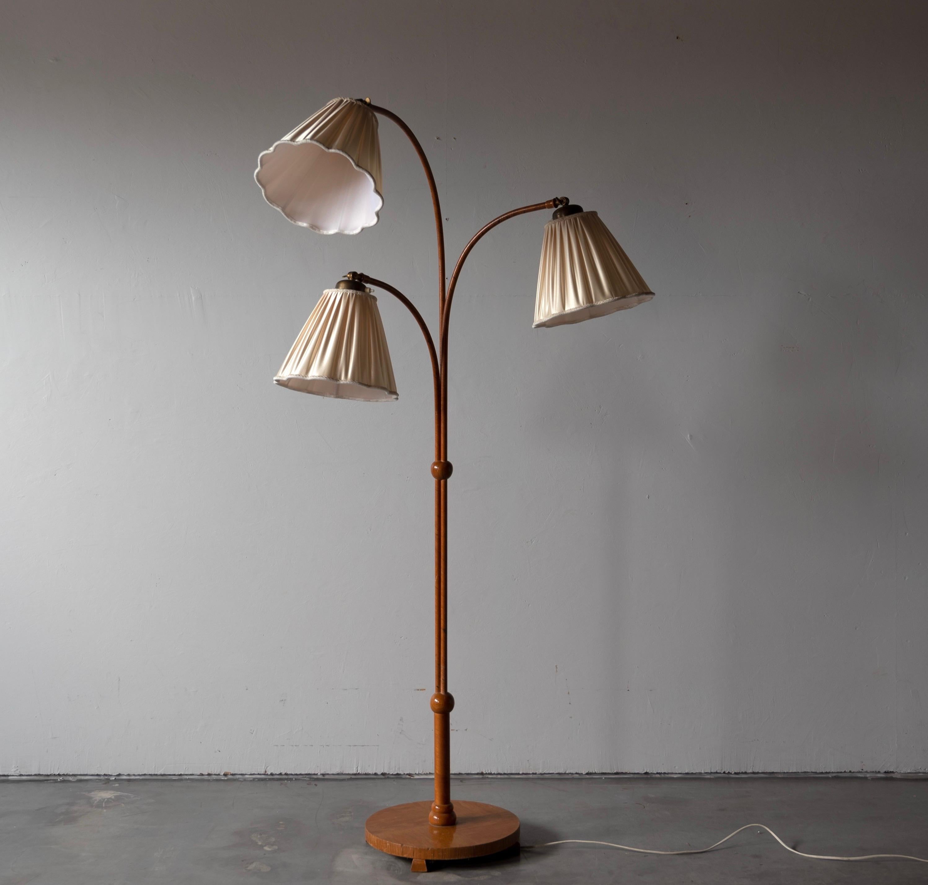 An three-armed floor lamp. Designed by an unknown Swedish modernist designer, 1930s. Produced in wood and brass. Brand new lampshades.

Other designers working in the organic style include Jean Royère, Gio Ponti, Vladimir Kagan, Ico Parisi, and
