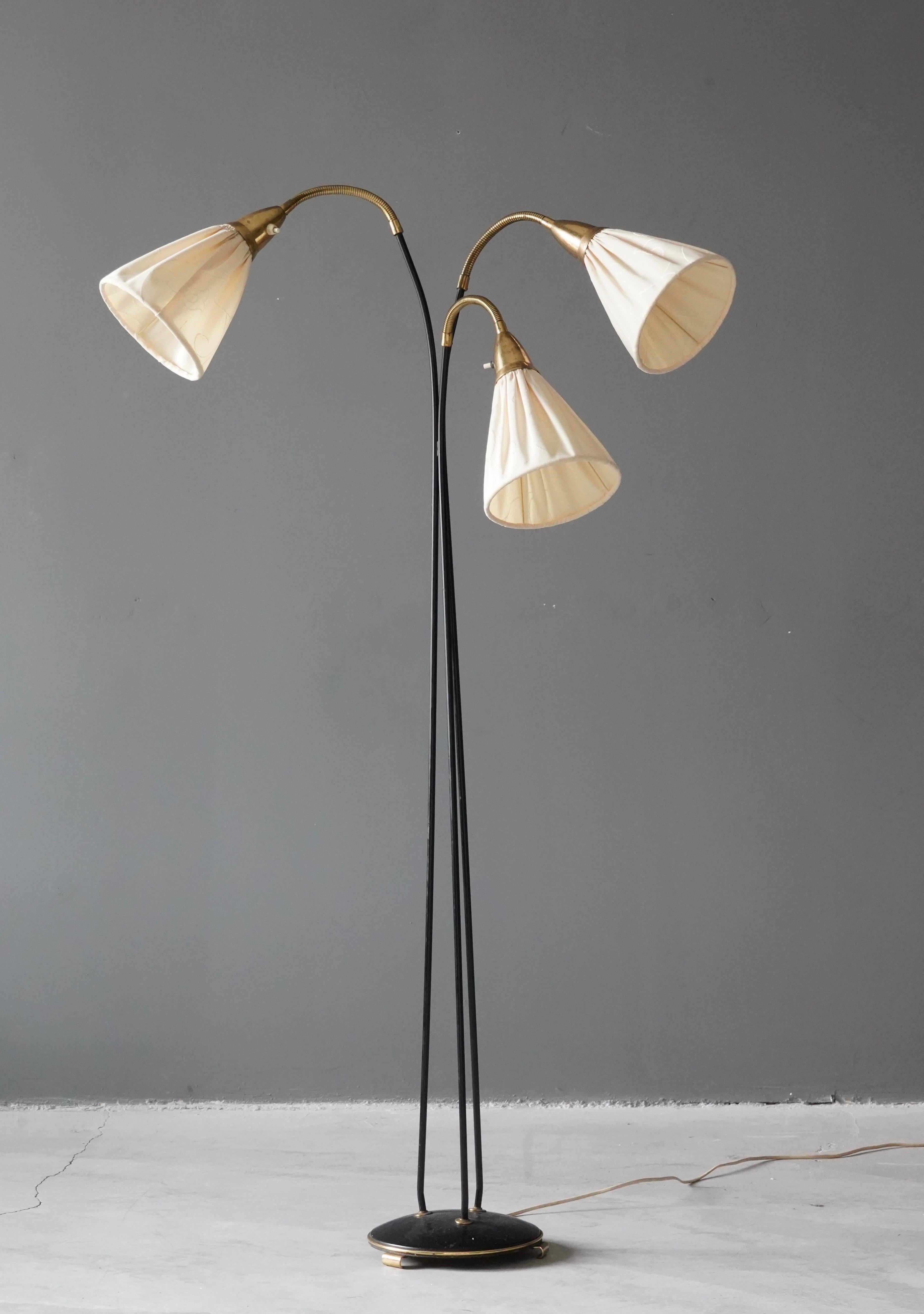An adjustable three-armed floor lamp. In lacquered metal, brass. Original fabric lampshades. 

Measured as illustrated. Vintage shades in good / fair condition. Buyer might want to update. 

Other designers of the period include Paavo Tynell,