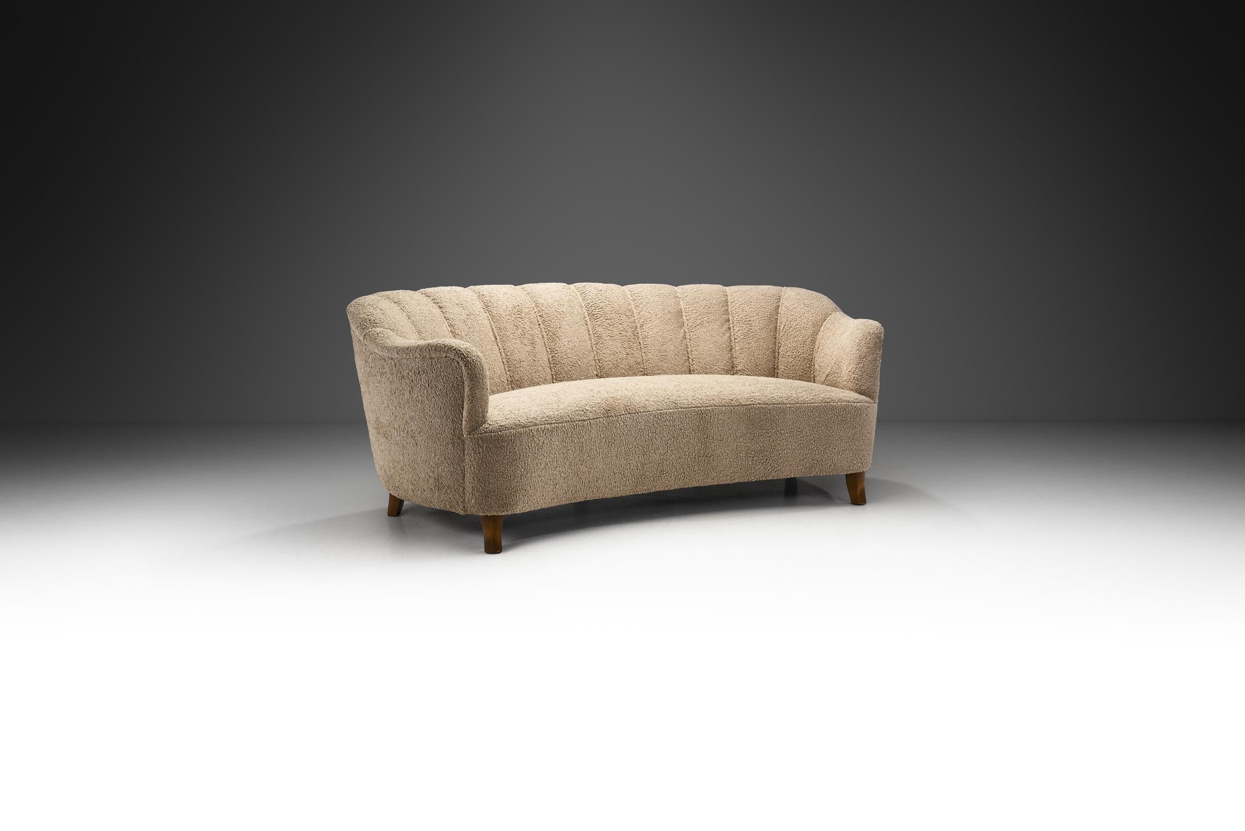 This beautiful Swedish three-seater sofa recalls the distinctive curves of the Art Deco period, while material and cabinetmaking-wise being a true Swedish Modern design. Thanks to its curved shape, this sofa is exceptionally cosy and elegant, a