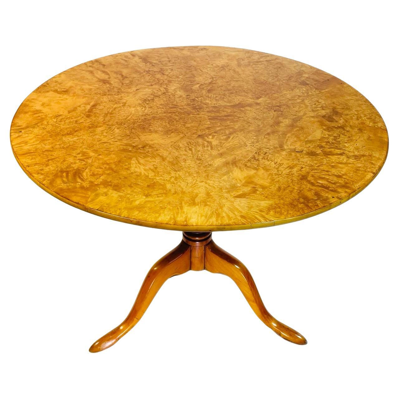 Introducing the exquisitely crafted Swedish Tilt Top Table in Birchwood Root Veneer, hailing from the picturesque Sweden of the 1940s. This timeless treasure is a captivating blend of sophistication and functionality, designed to elevate any living