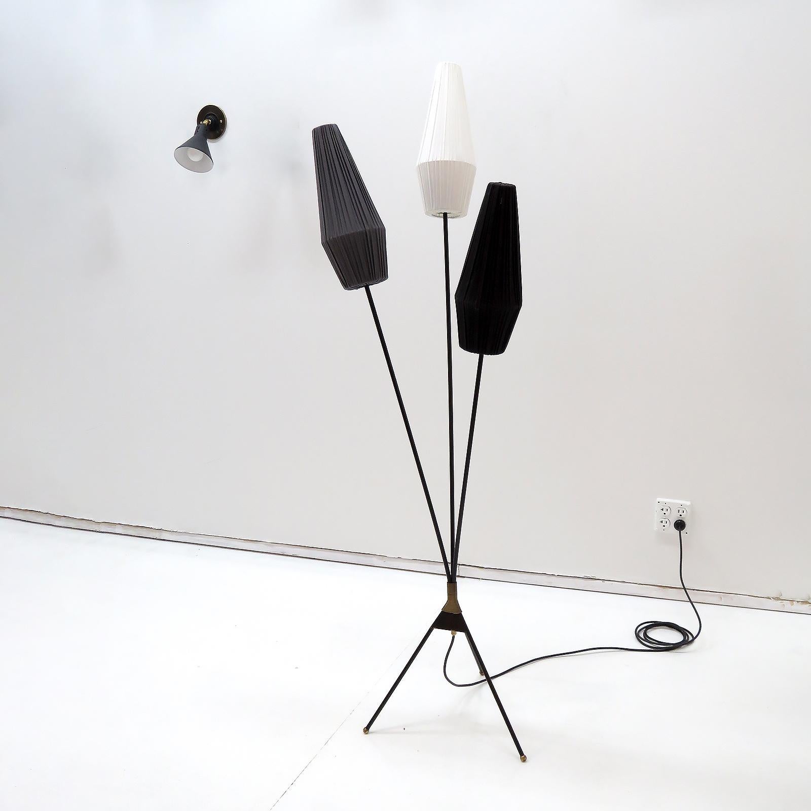 Wonderful 1950s Swedish tripod floor lamp, 1950, in black enamel with brass accents, with three tricolored fabric clip on shades, on/off switch at the convergence point of the three arm/legs, three E26 sockets, max. wattage 60w each, wired for US