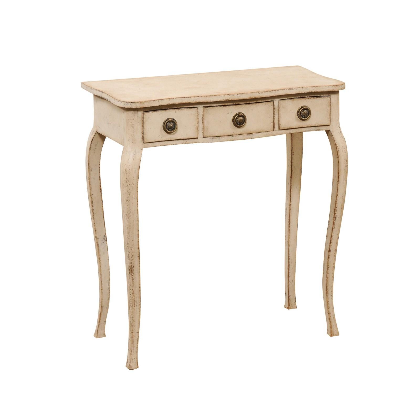 A Swedish Turn of the Century painted wood console table from the early 20th century, with serpentine front, three drawers and cabriole legs. Created in Sweden at the Turn of the Century which saw the transition between the 19th to the 20th, this