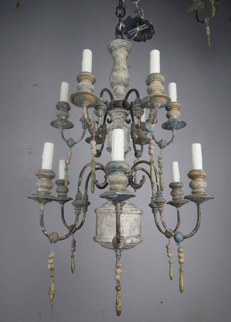 Twelve-light Swedish wood and iron painted chandelier with wood drops throughout. Beautiful worn painted finish. The chandelier have been newly rewired with drip wax candle covers. Chain and canopy included.