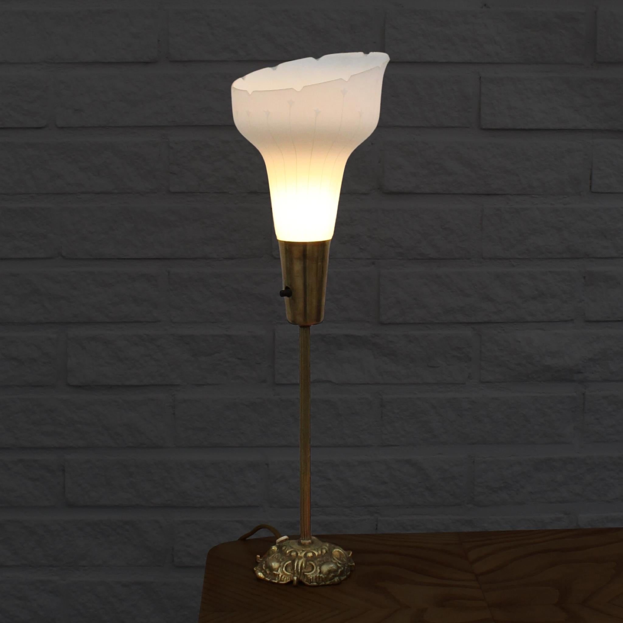 Lampe de table suédoise à éclairage vers le haut produite par Eric Wärnå à Värnamo. La base de la lampe est en laiton et comprend un interrupteur intégré. Elle est ornée d'un abat-jour en verre gravé présentant un motif géométrique attrayant. Le